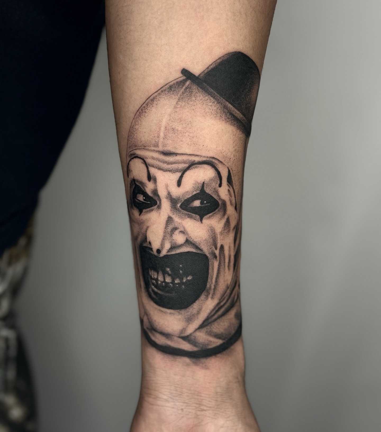 Clown realism tattoo on the forearm by โโฎโ๐ถ๐๐ฝ๐๐๐ู เฃชโญ las vegas tattoo artist