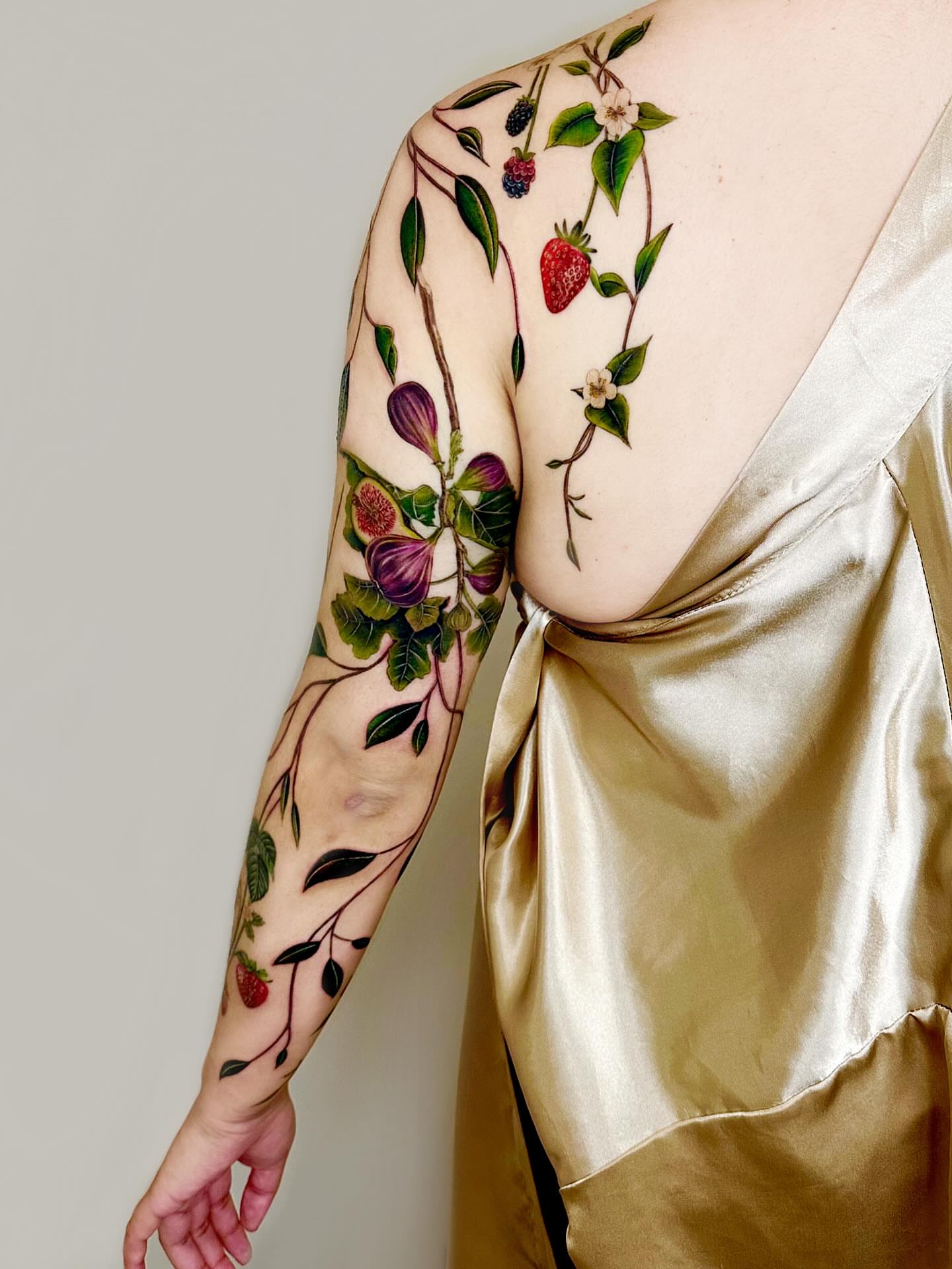 Botanical realism tattoo on the upper arm by Claire