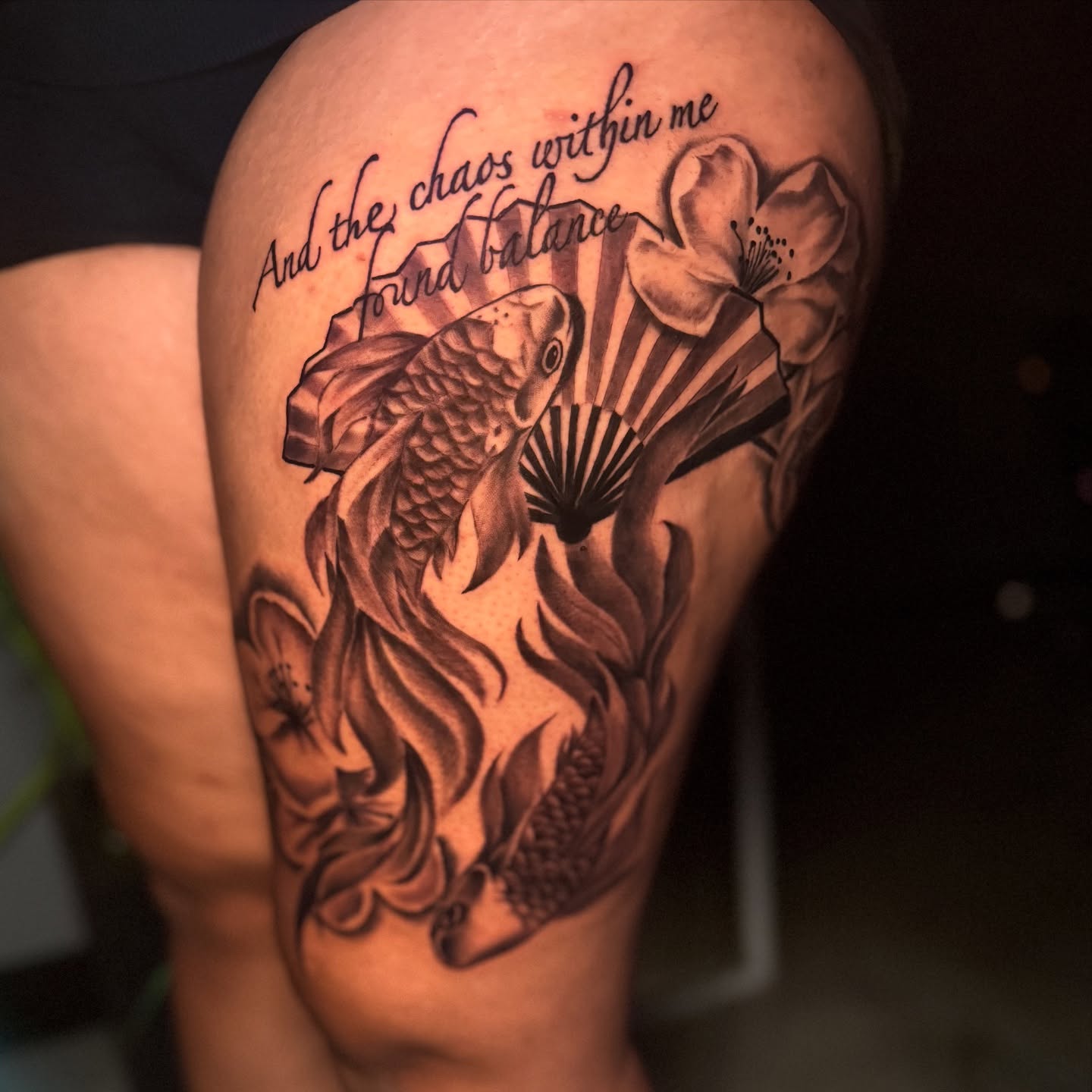 Koi fish and cherry blossom realism tattoo on the upper arm by Butta