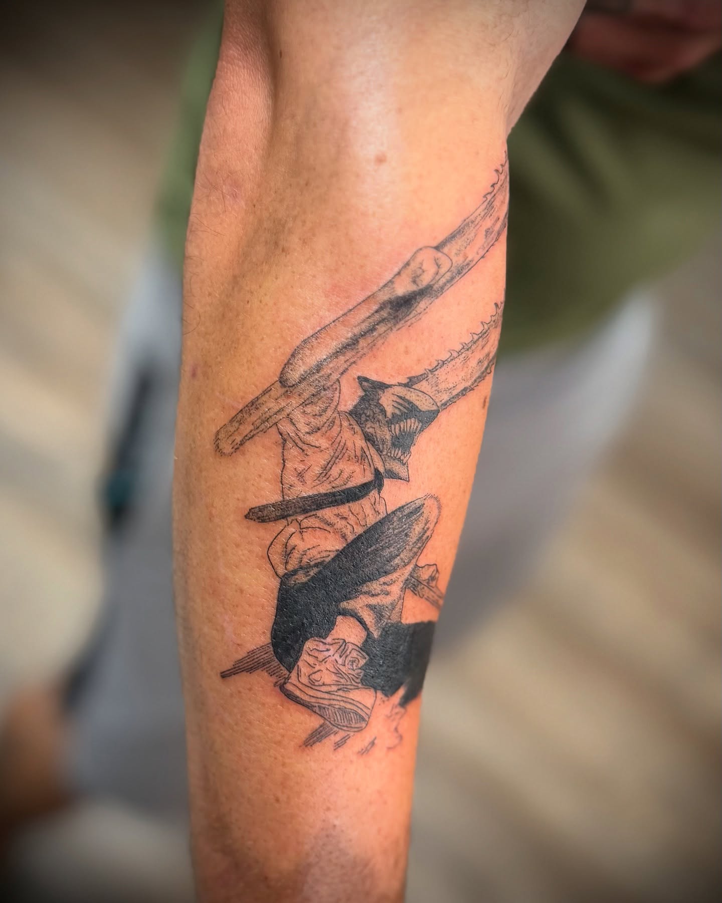 Chainsaw operator black and grey tattoo on the forearm by Justin Bianchini - New Orleans Tattoo Artist