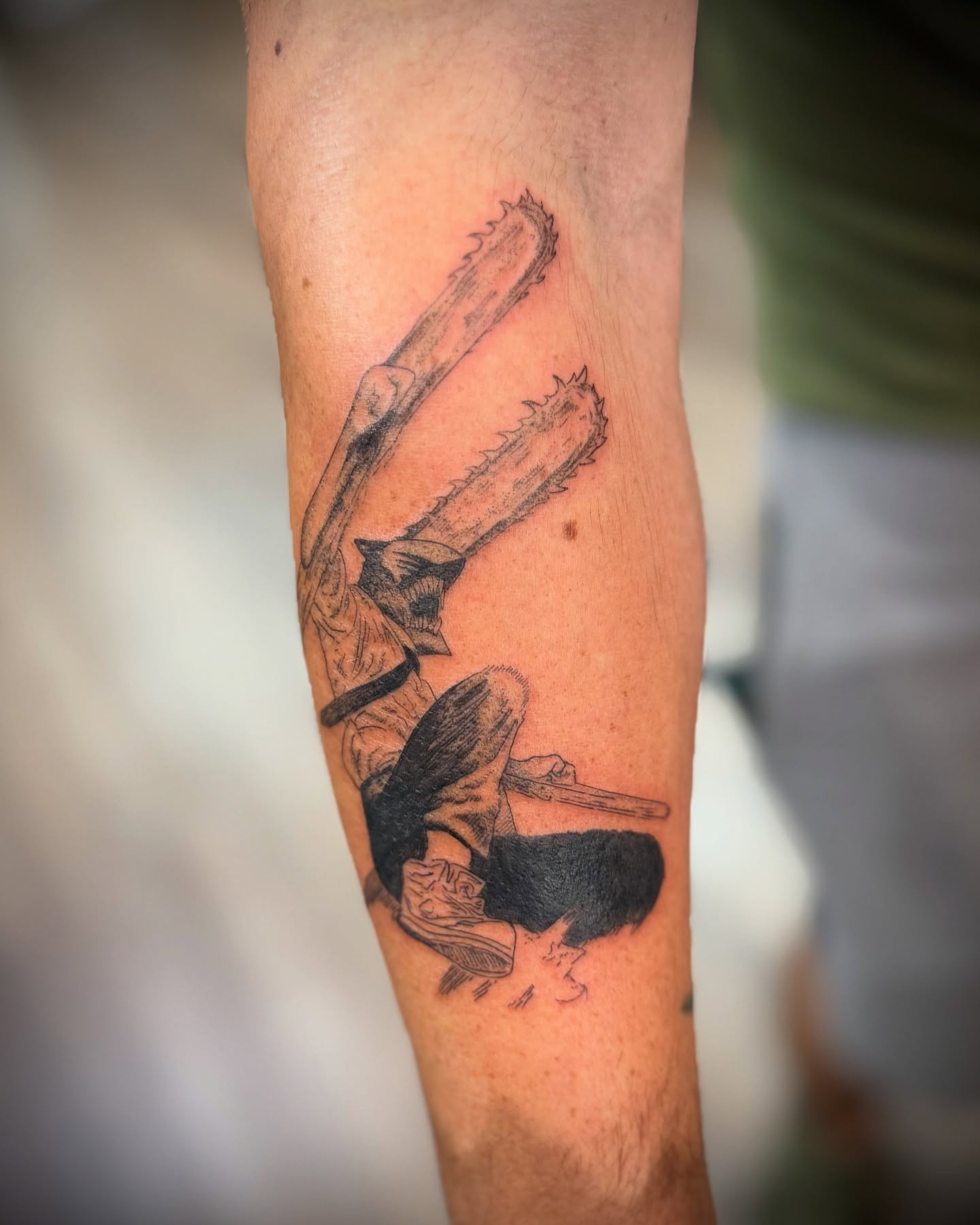 Chainsaw and figure black and grey tattoo on the forearm by Justin Bianchini - New Orleans Tattoo Artist