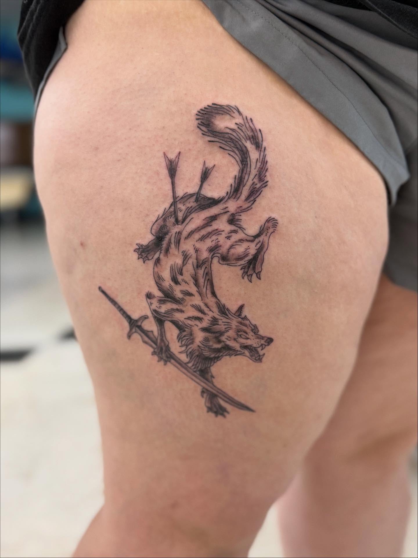 Wolf with arrows black and grey tattoo on the thigh by Levi Sawdon, Everett, Washington