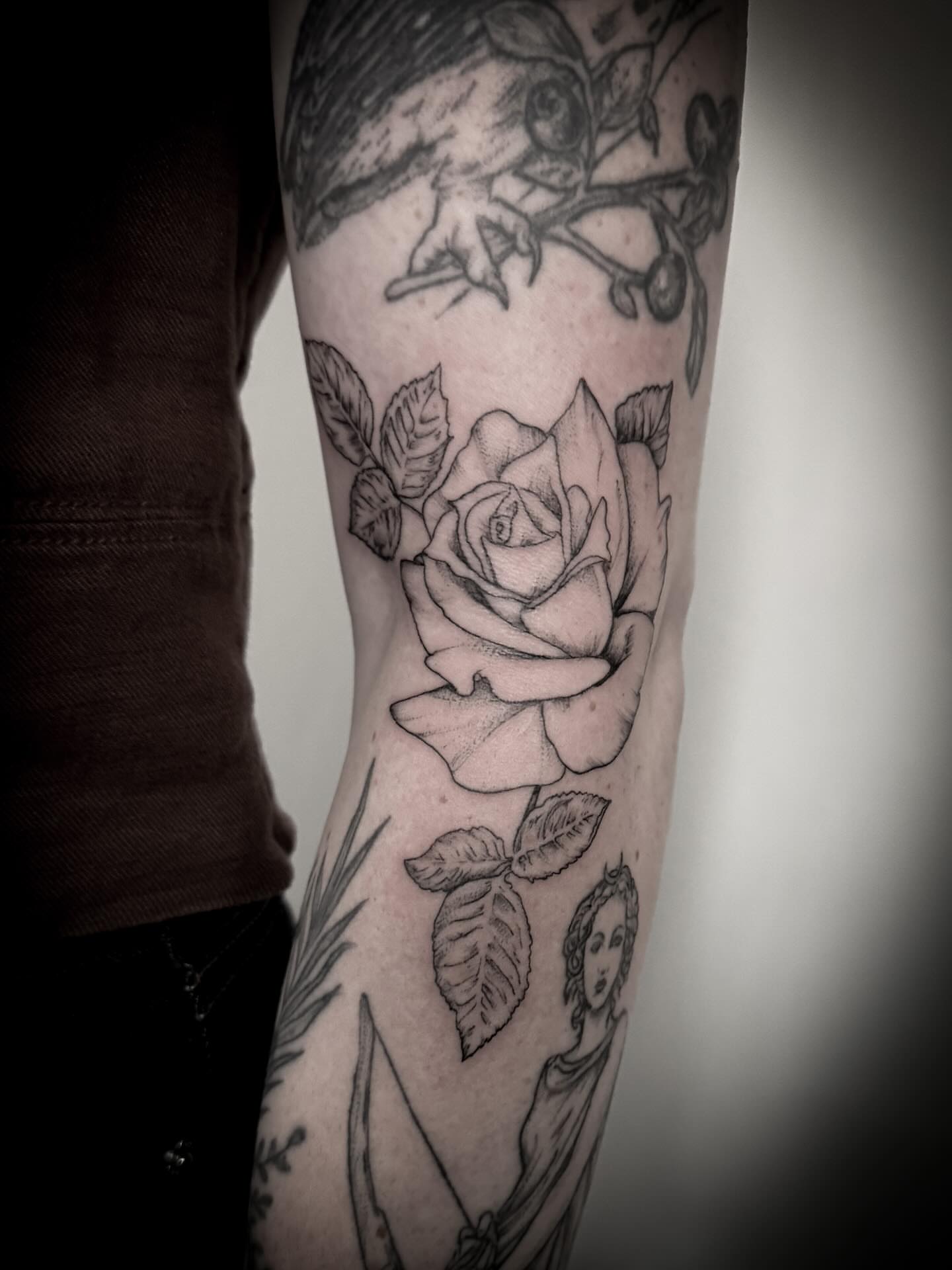 Rose and cherub realism tattoo on the forearm by Christen Wolfe CA Tattooer