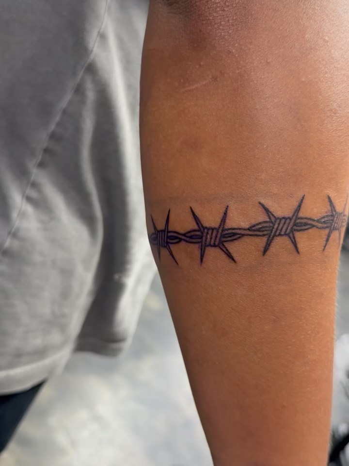 Barbed wire black and grey tattoo on the forearm by Kylee langford 🧿