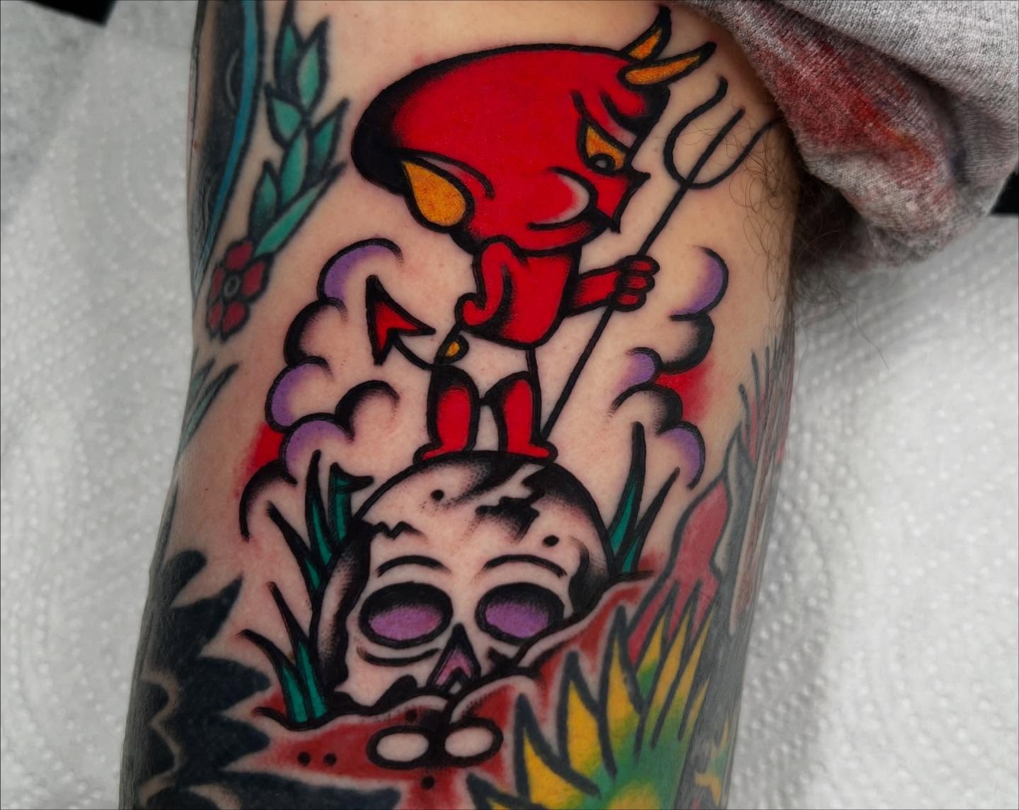 Red devil with pitchfork American traditional tattoo on the forearm by Kevin Caruso
