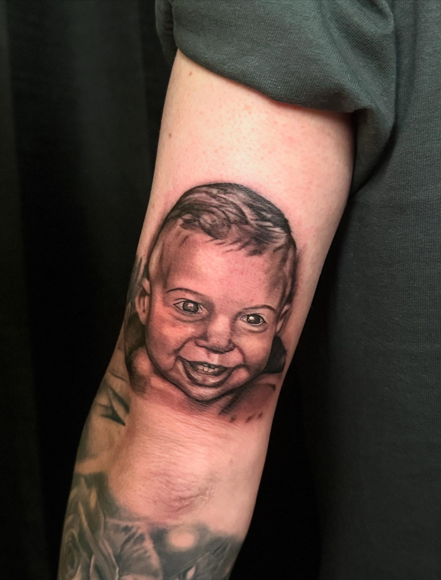 Child's face realism tattoo on the forearm by Tanner Pastor
