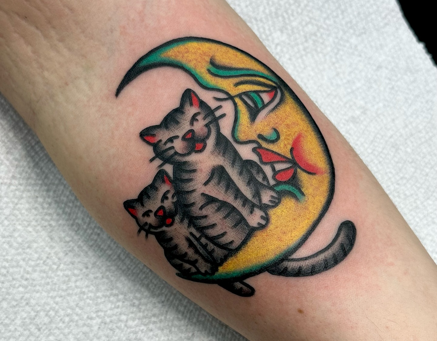 Two cats on moon American traditional tattoo on the forearm by Amanda Bonhomme, Las Vegas, Nevada