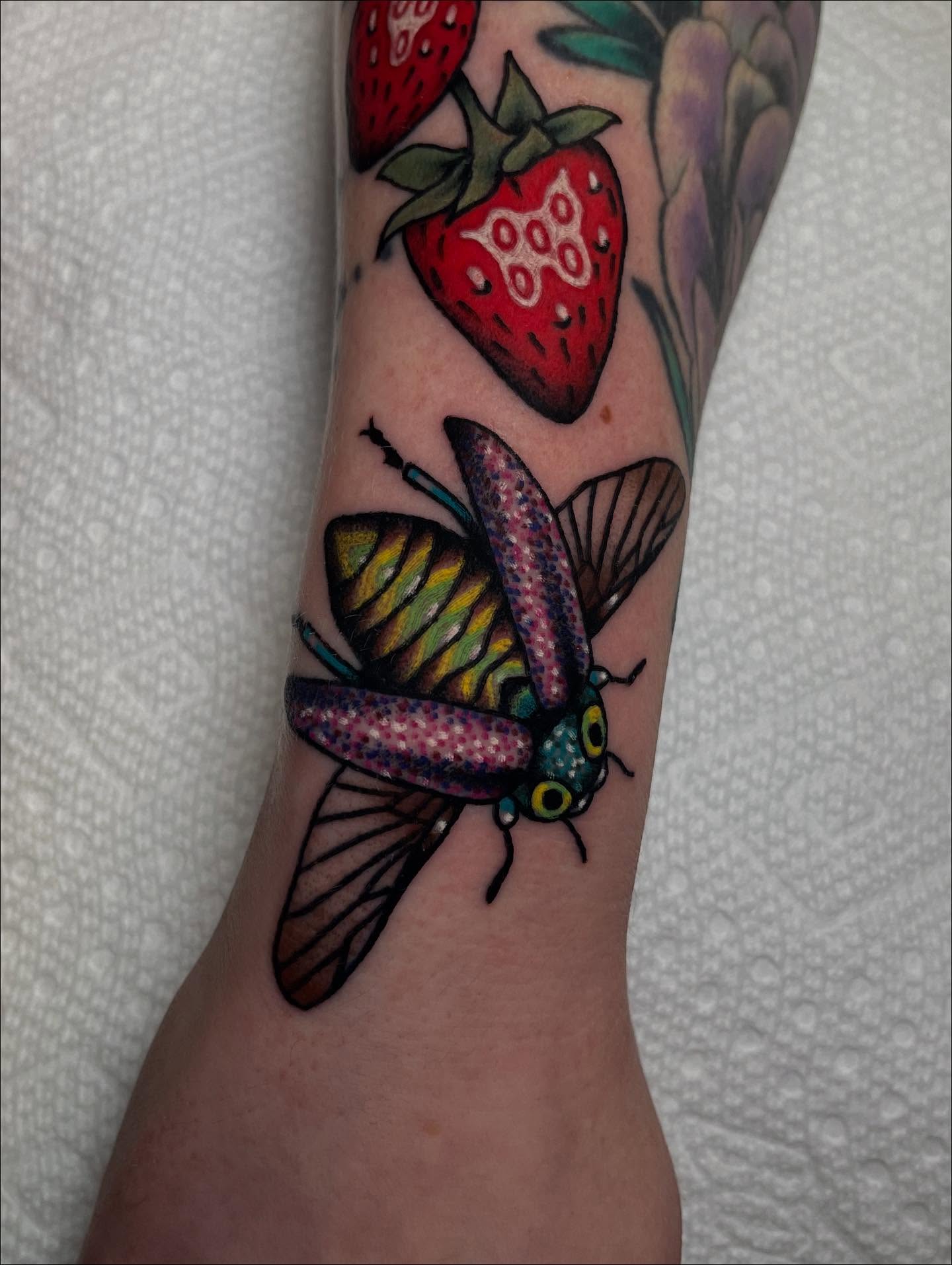 Butterfly and strawberries American traditional tattoo on the forearm by Marqui Watling