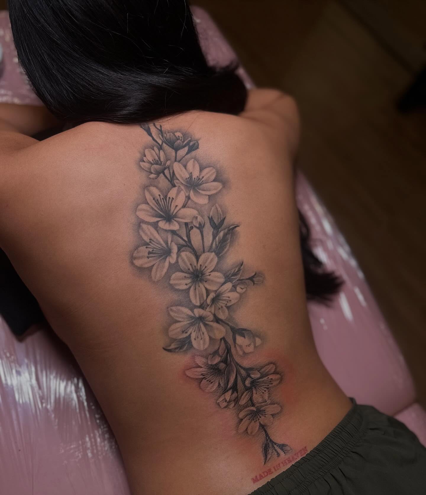 Cherry blossom branch black and grey tattoo on the back by 𝒲𝒾𝓃𝑜𝓃𝒶