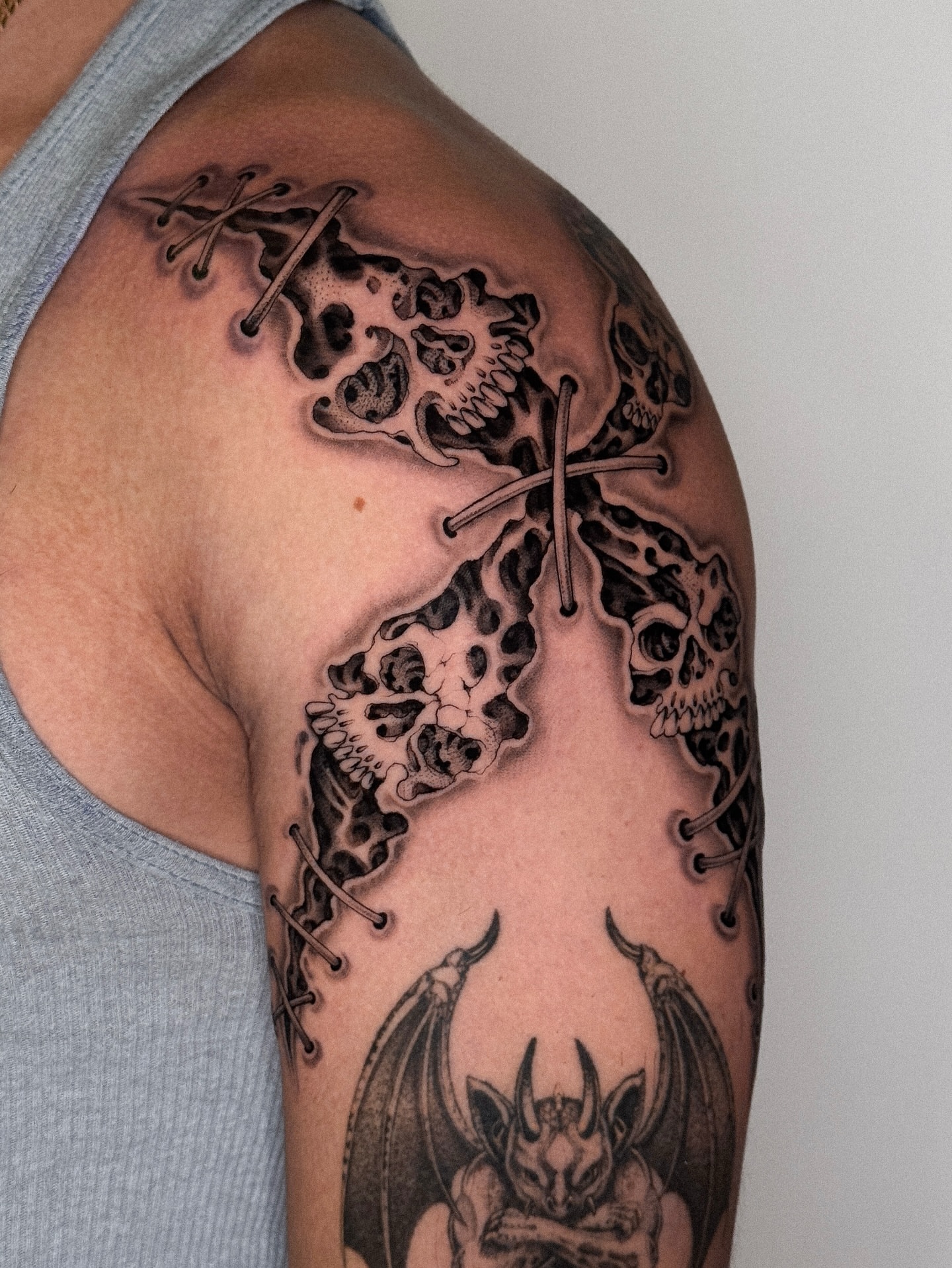 Skulls and bats dark realism tattoo on the upper arm by ella