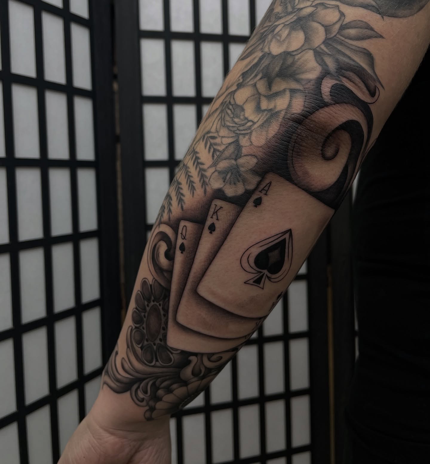 Playing cards black and grey tattoo on the forearm by kaylee