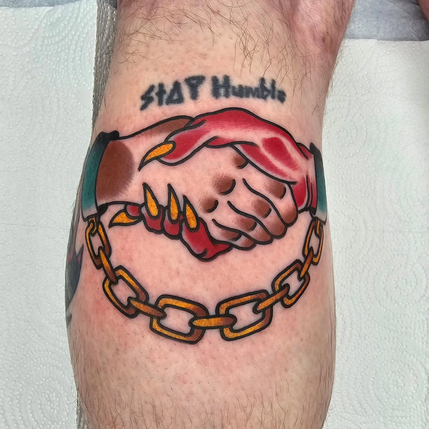 Shake hands with chains American traditional tattoo on the forearm by Adam Garnek
