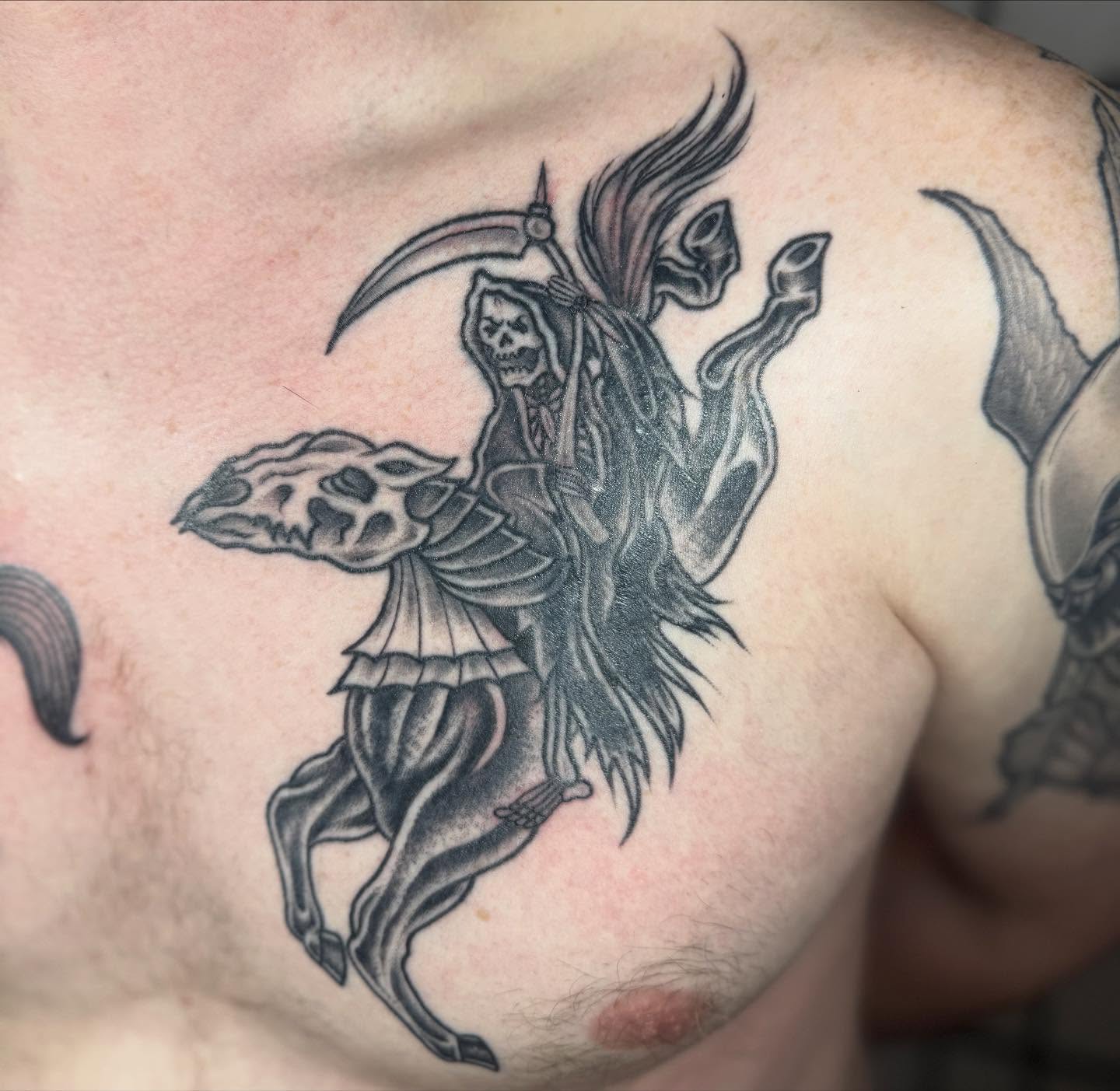 Grim reaper on horseback black and grey tattoo on the chest by Justina🪐