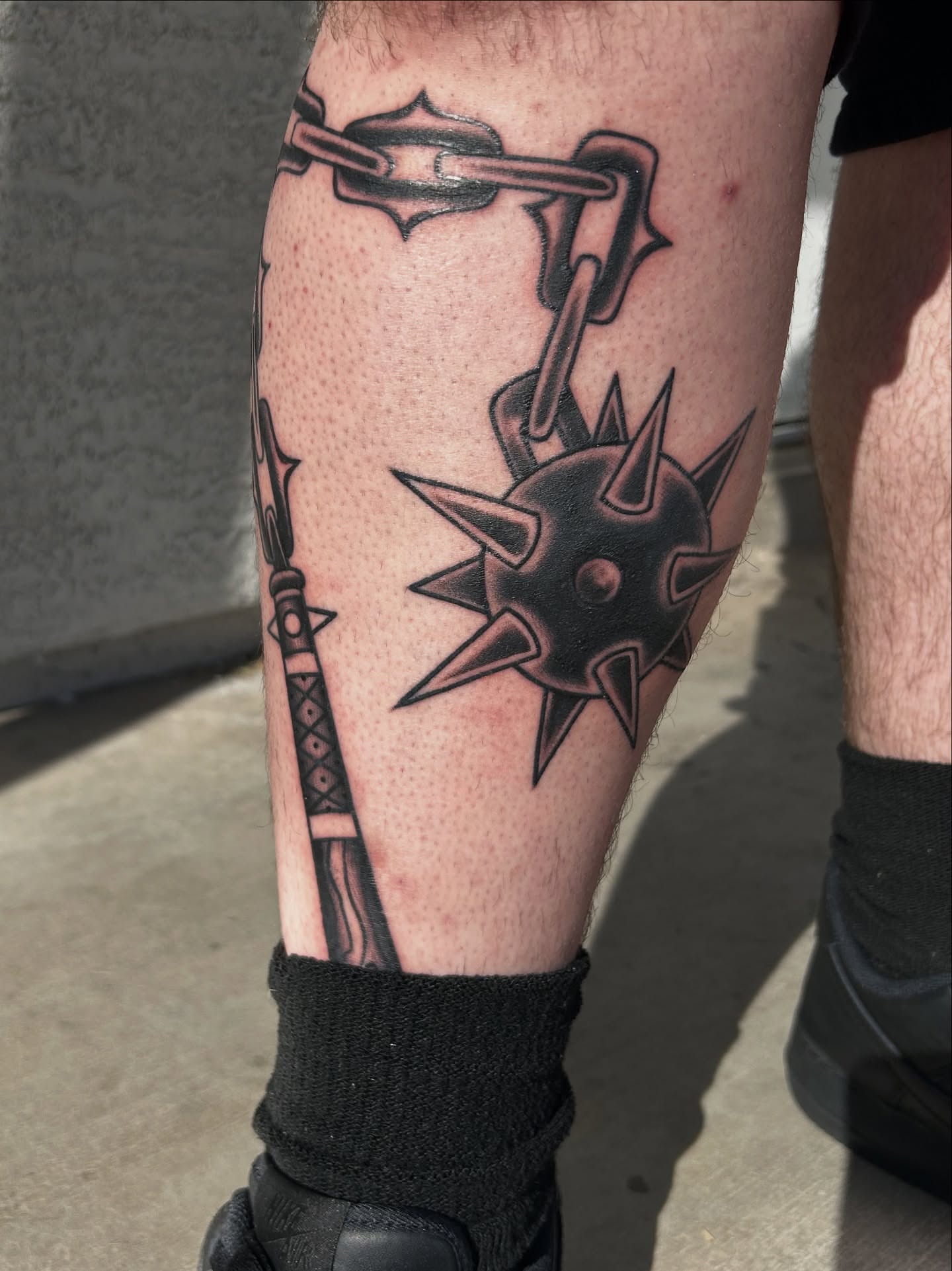 Spiked shield and chain black and grey tattoo on the calf by Tattoos by Corey aka MrLu