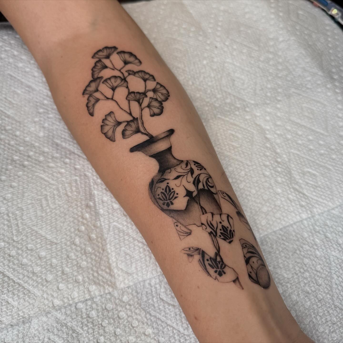 Flower vase with fish realism tattoo on the forearm by Jas Knight