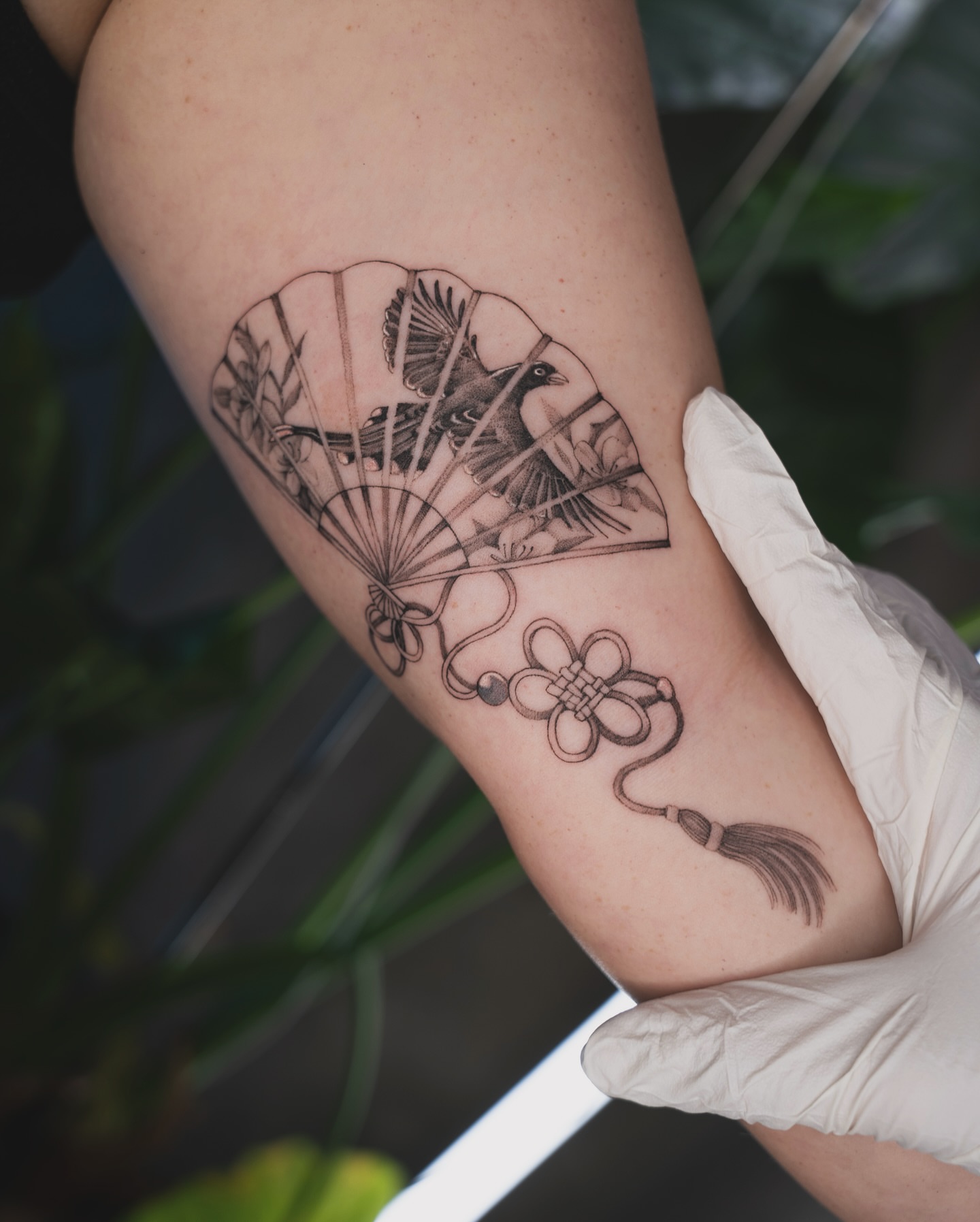 Fan and birds black and grey tattoo on the forearm by Tri