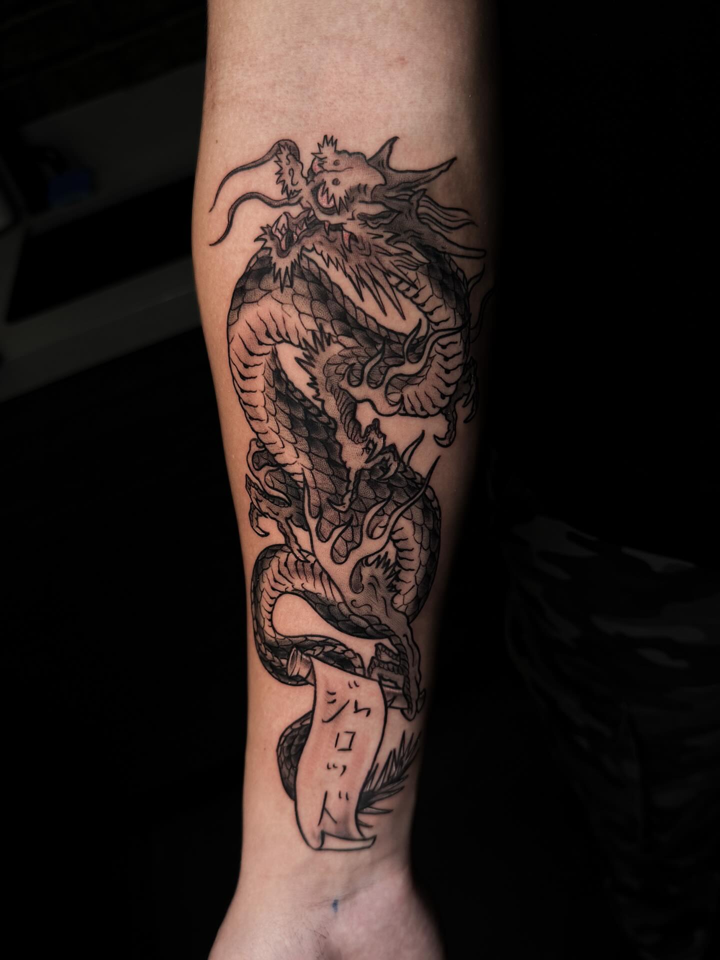 Dragon black and grey tattoo on the forearm by Demi DiMartino