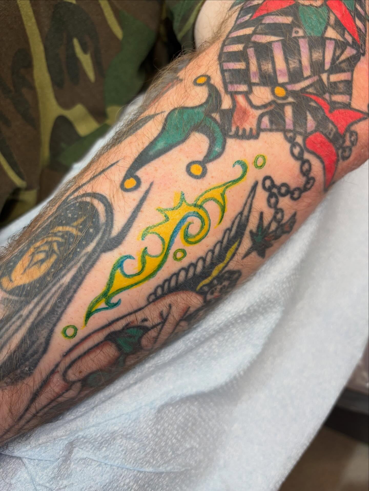 Jester and flame American traditional tattoo on the forearm by Emmy Gallagher