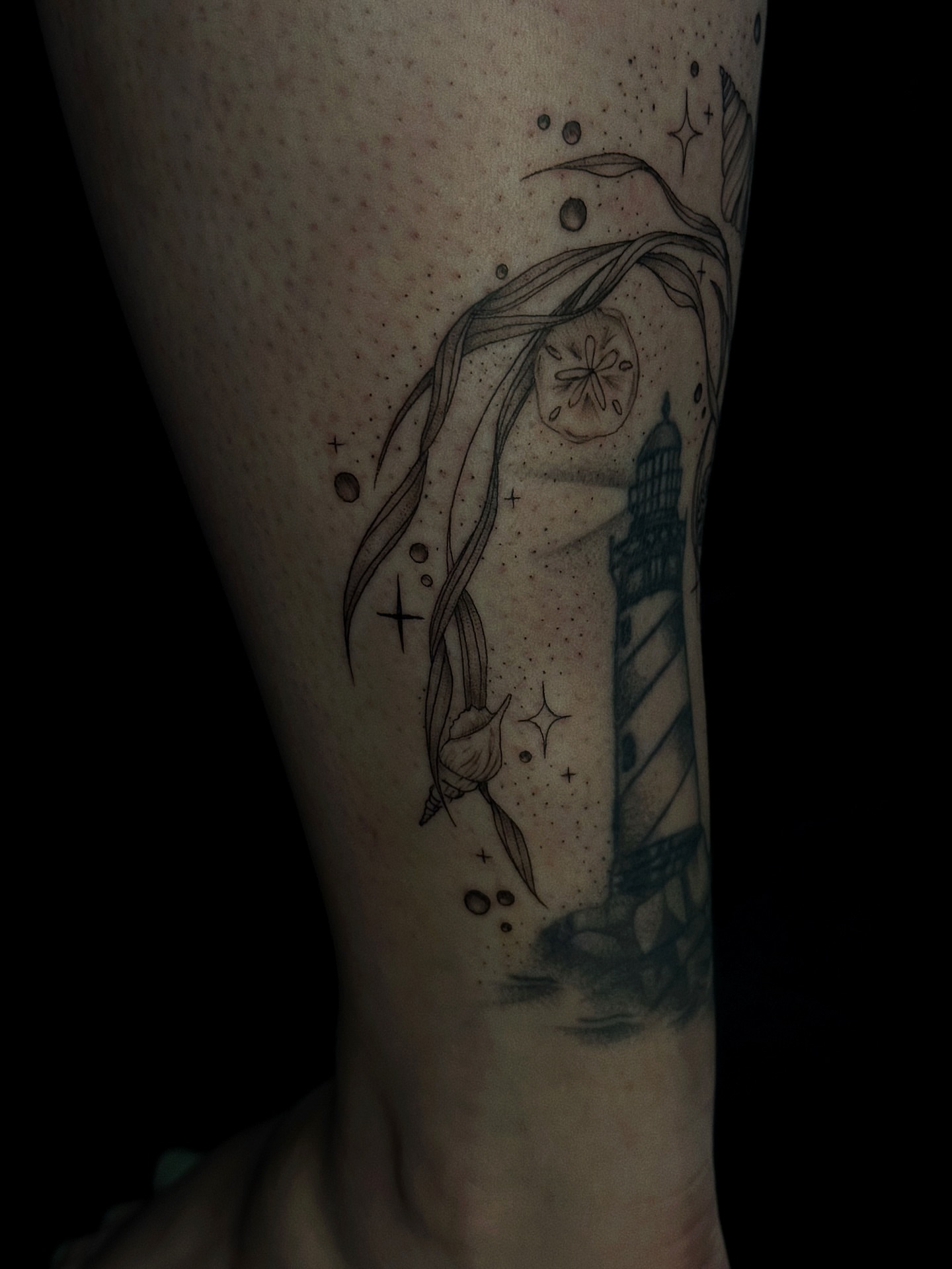 Lighthouse and mermaid black and grey tattoo on the forearm by elena