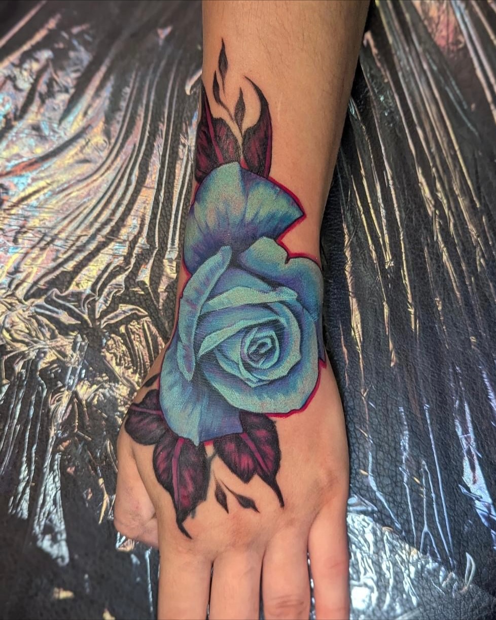 Blue rose realism tattoo on the hand by Bethany Jane Tattoos