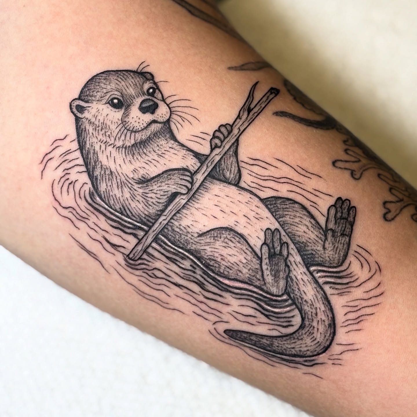 Otter black and grey tattoo on the forearm by Robert McCollum