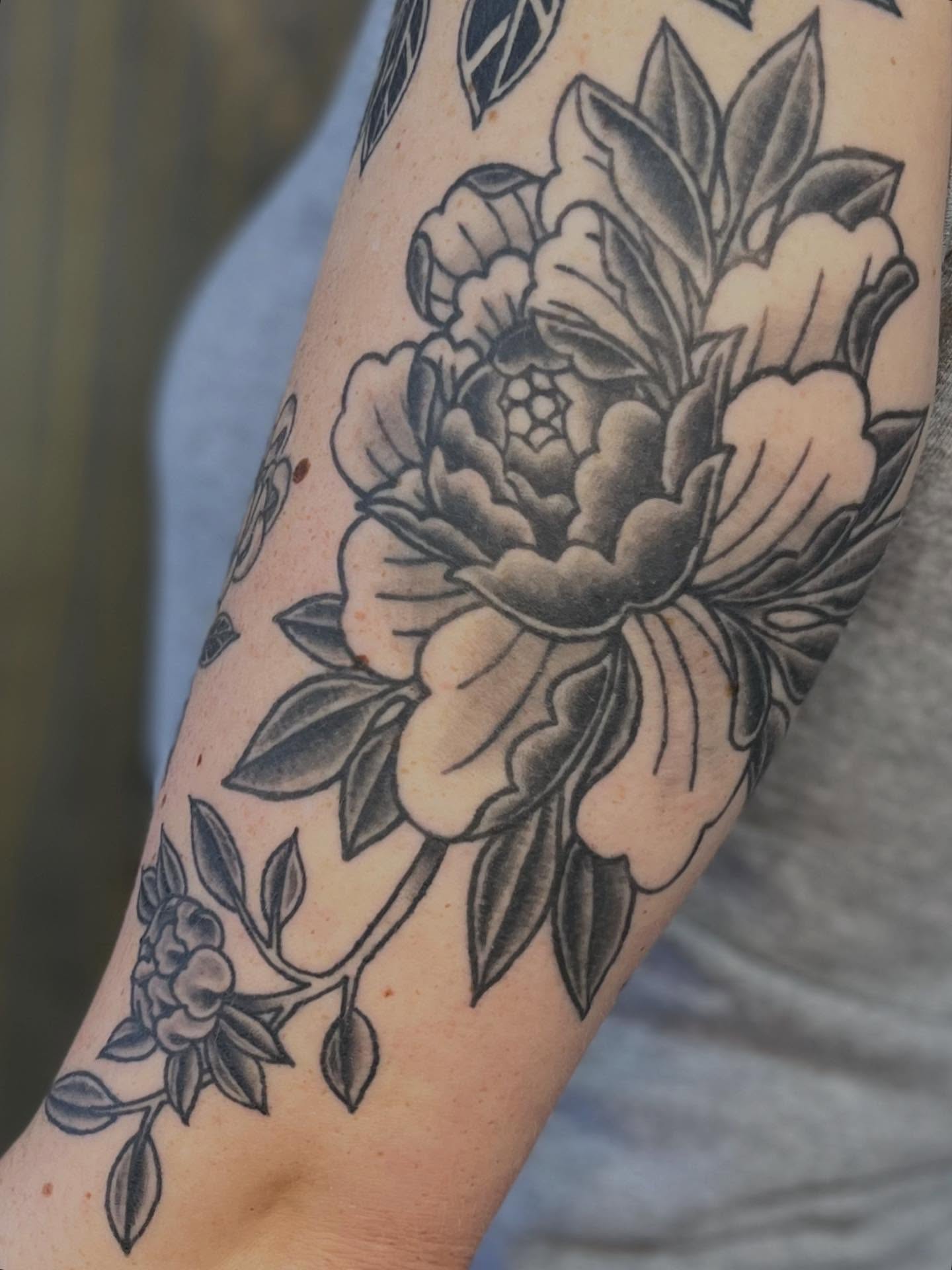 Peony black and grey tattoo on the forearm by Riley McDonald