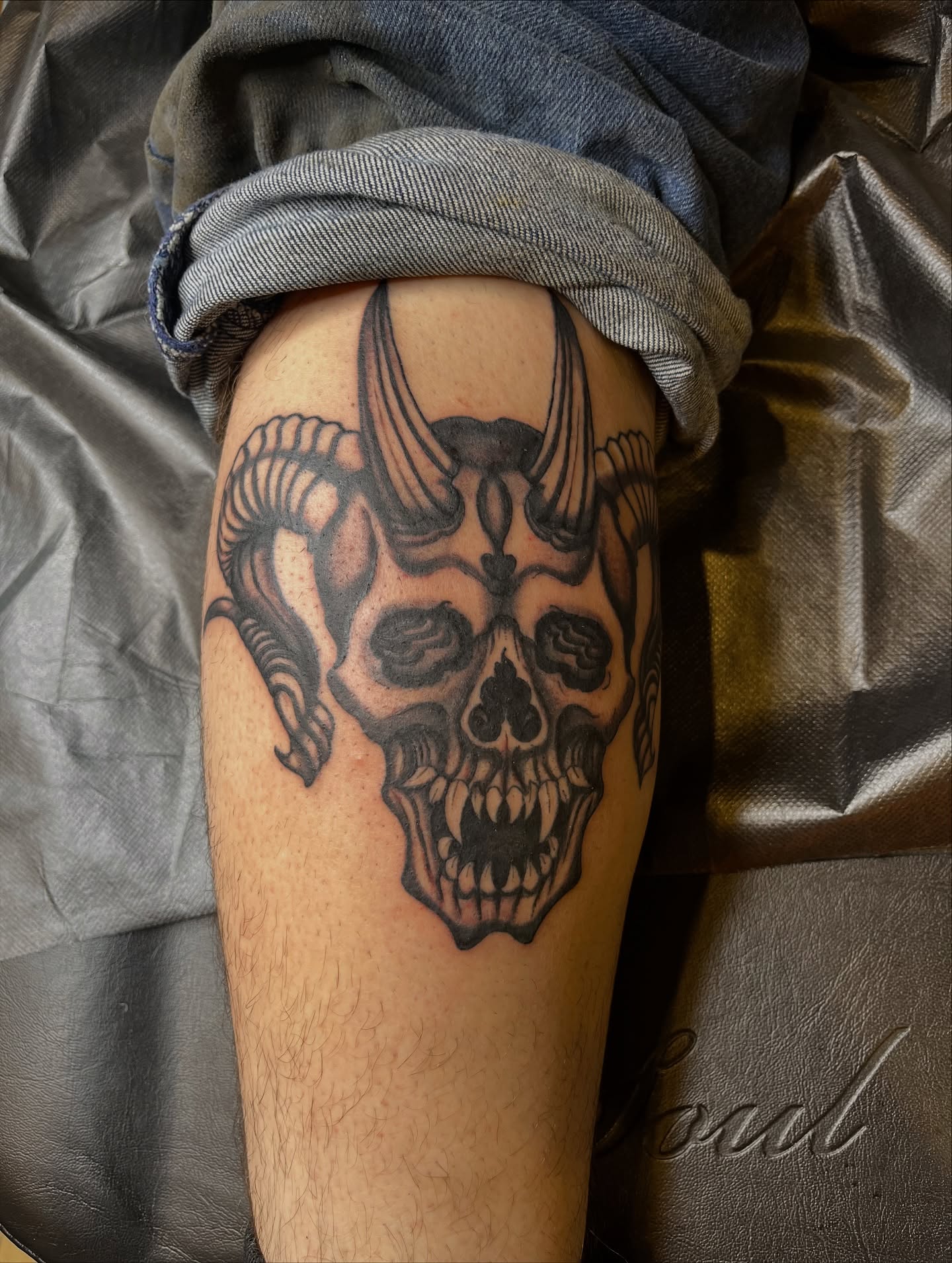 Skull with horns black and grey tattoo on the thigh by Winston Thai