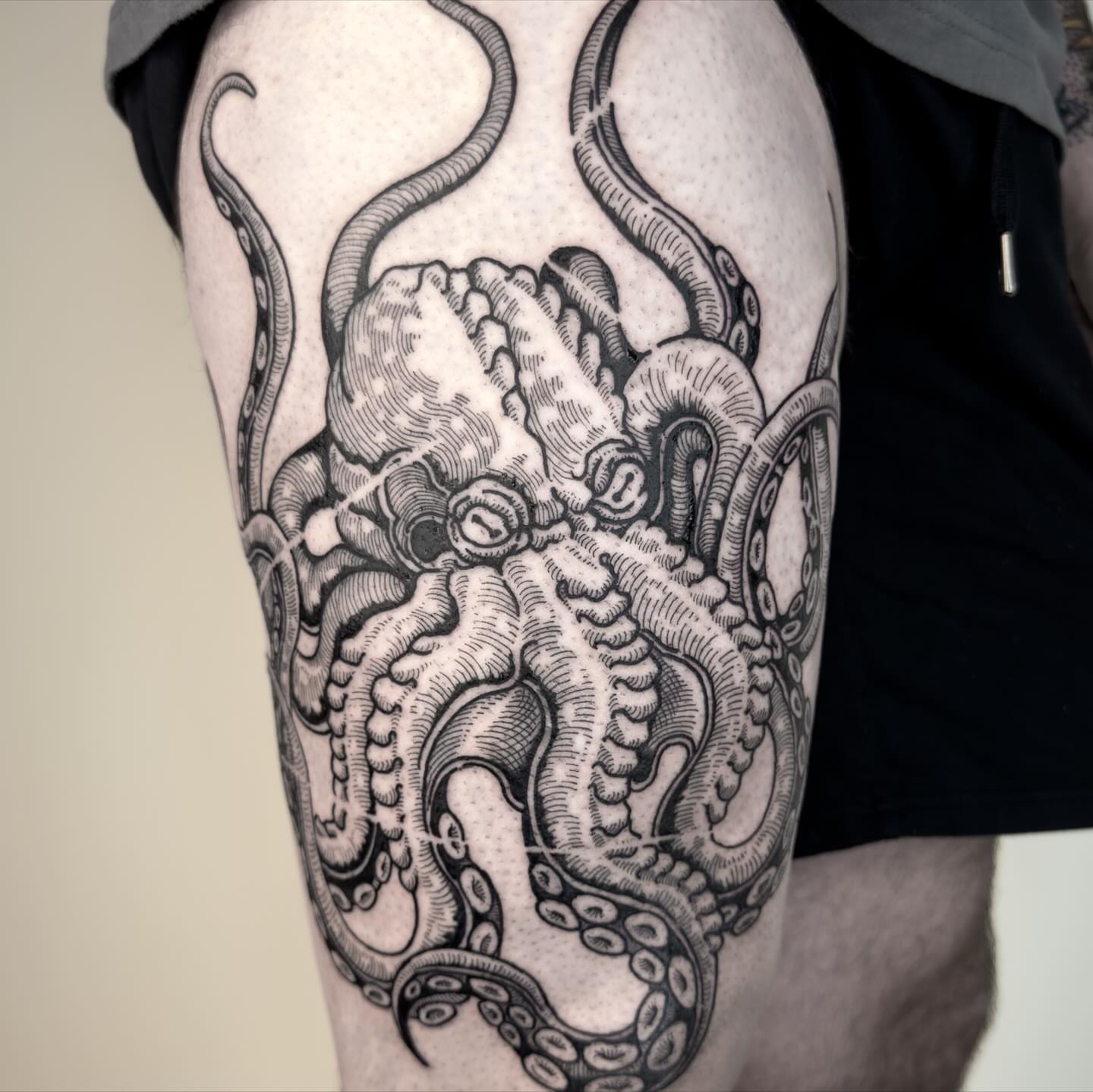Octopus black and grey tattoo on the thigh by Dokk