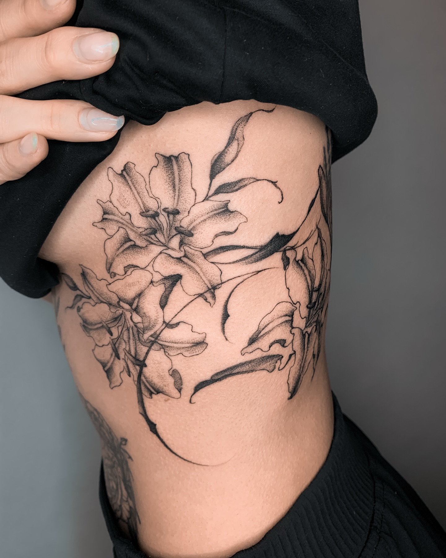 Lily black and grey tattoo on the ribs by 21 tattooist