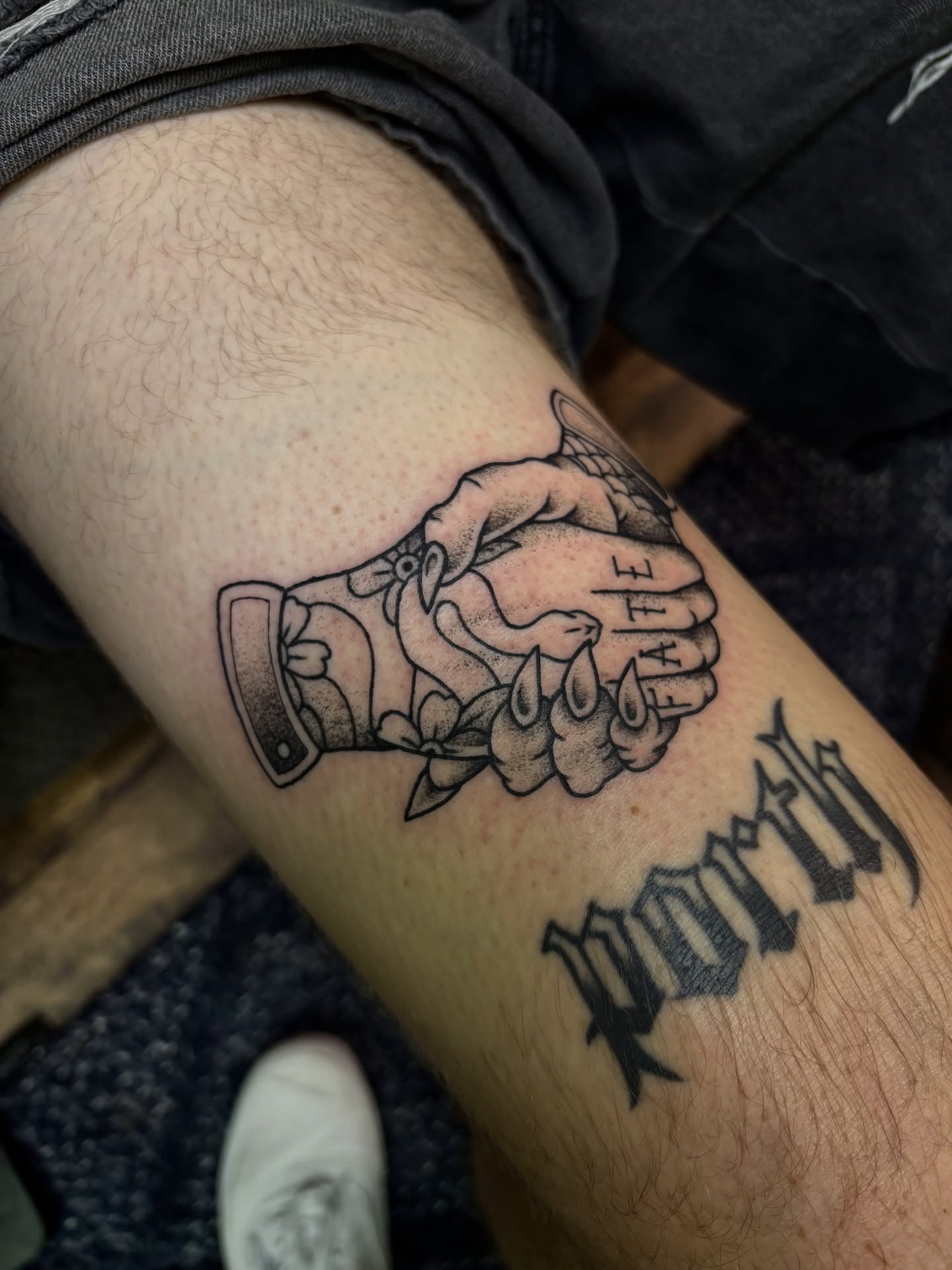 Handshake black and grey tattoo on the forearm by Dyllan Shipley