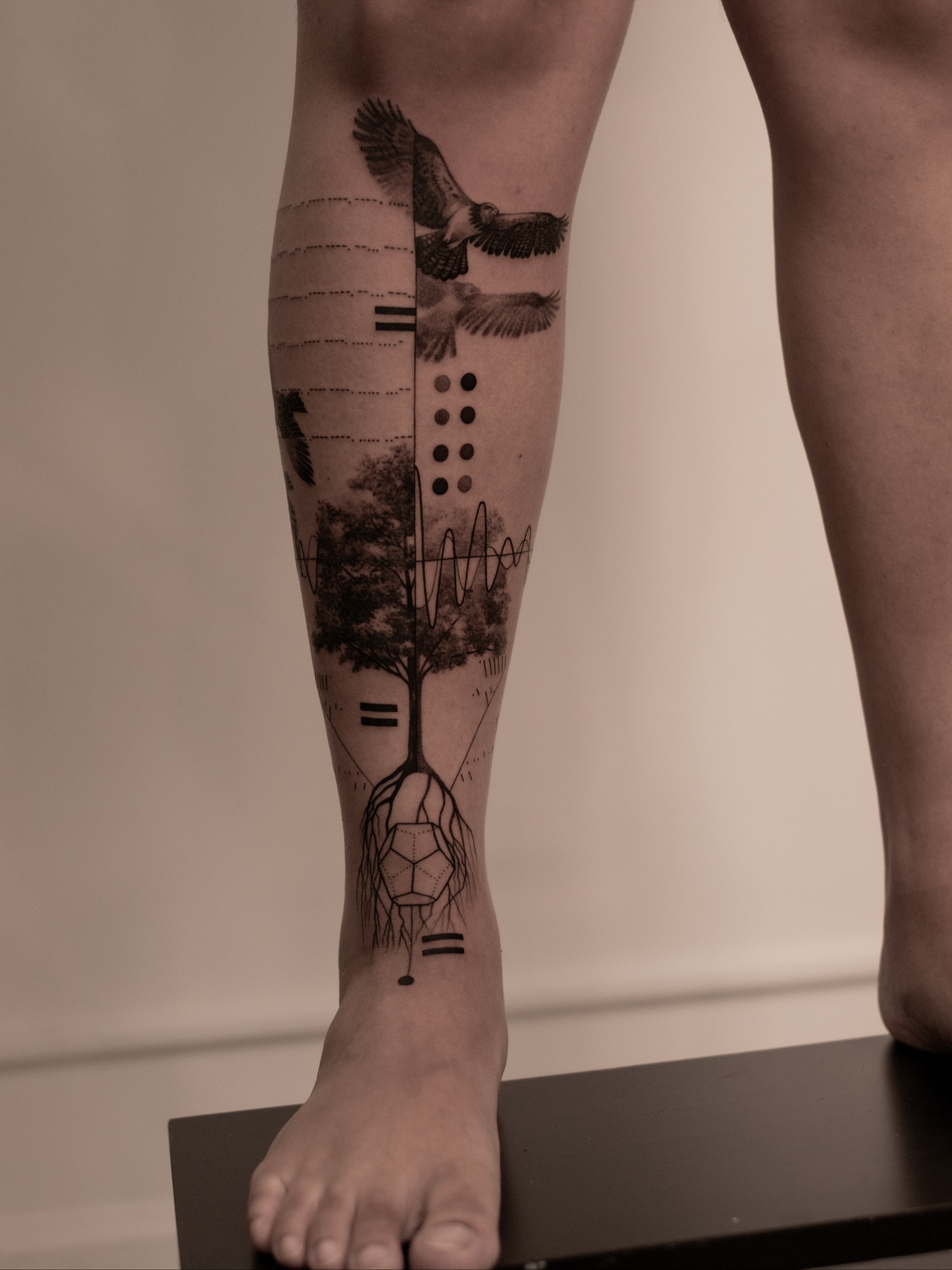 Bird and tree dotwork tattoo on the calf by Mark D, Los Angeles, California