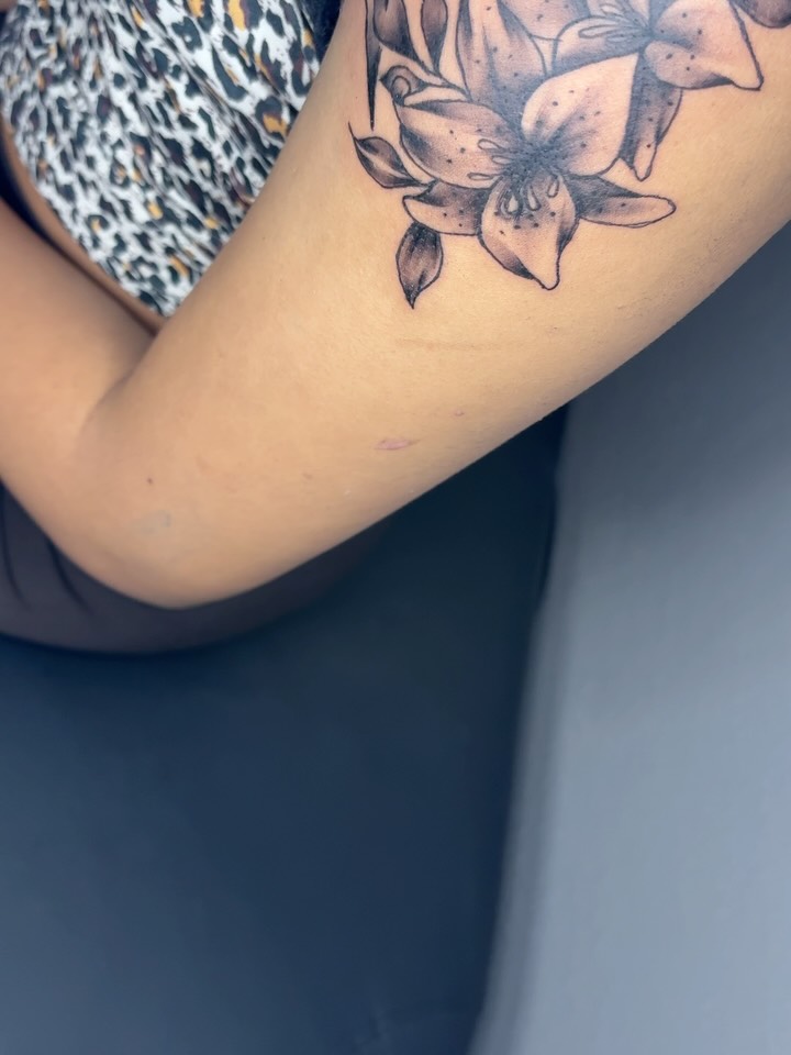 Lotus flowers black and grey tattoo on the forearm by Maleek Inkz