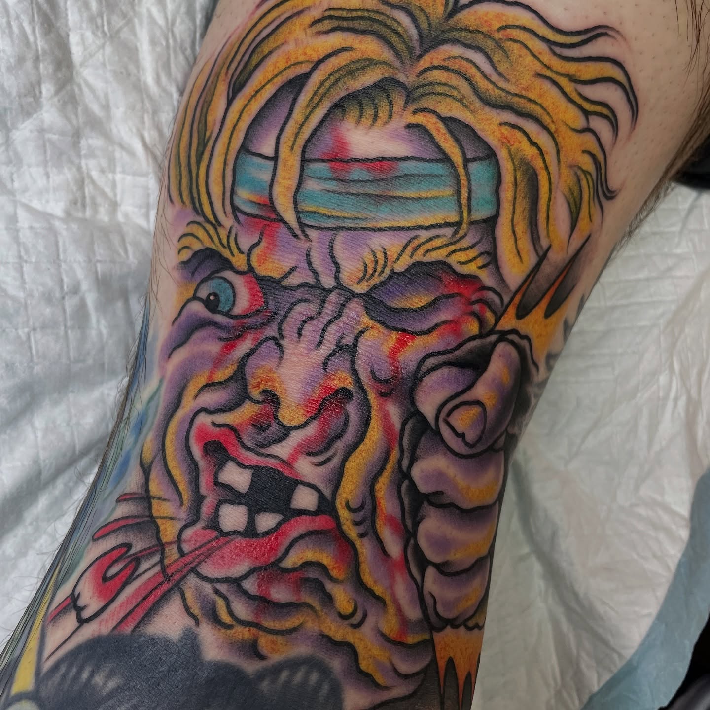 Angry face American traditional tattoo on the forearm by Tom Taylor, Philadelphia, Pennsylvania