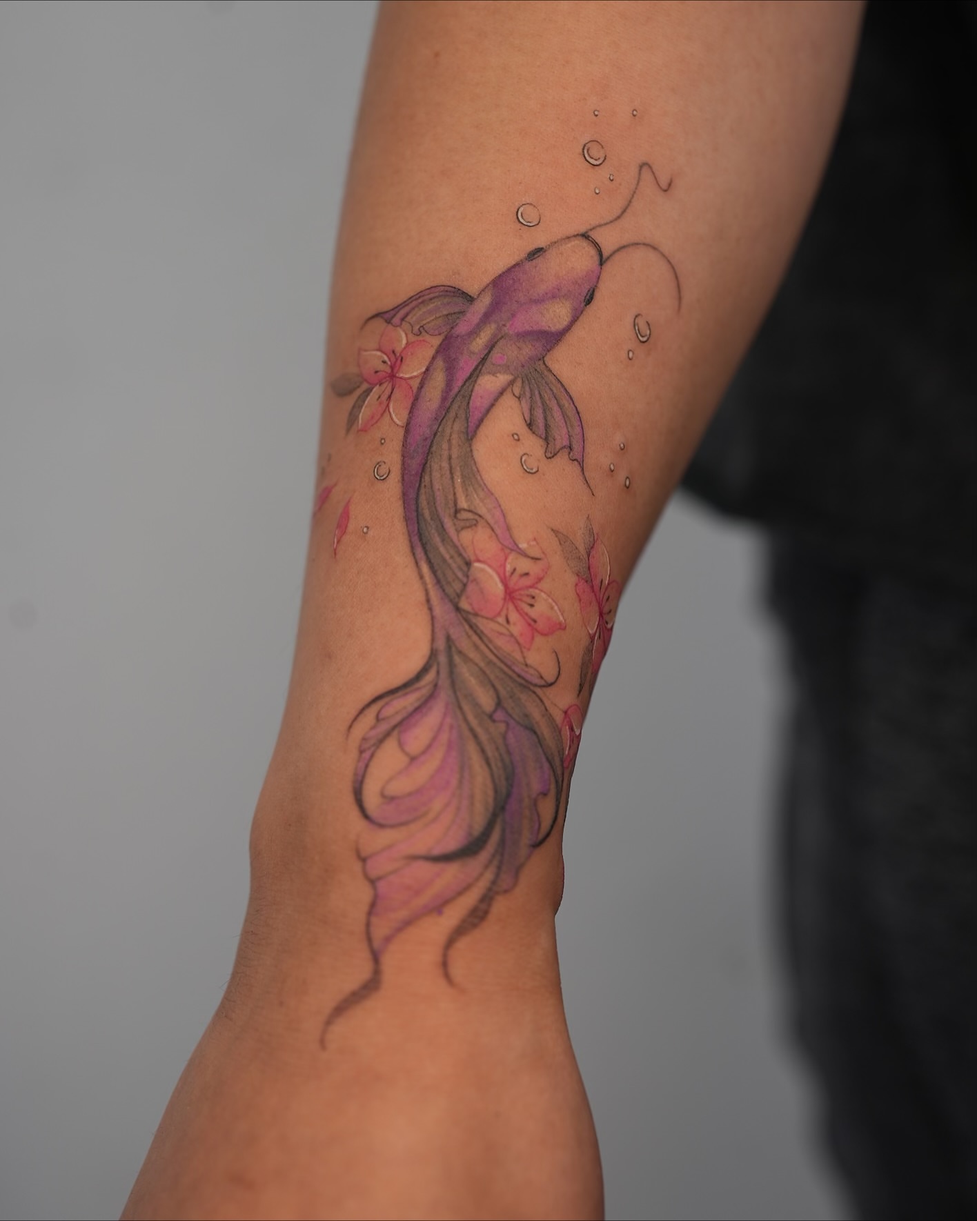 Koi fish watercolor tattoo on the forearm by X
