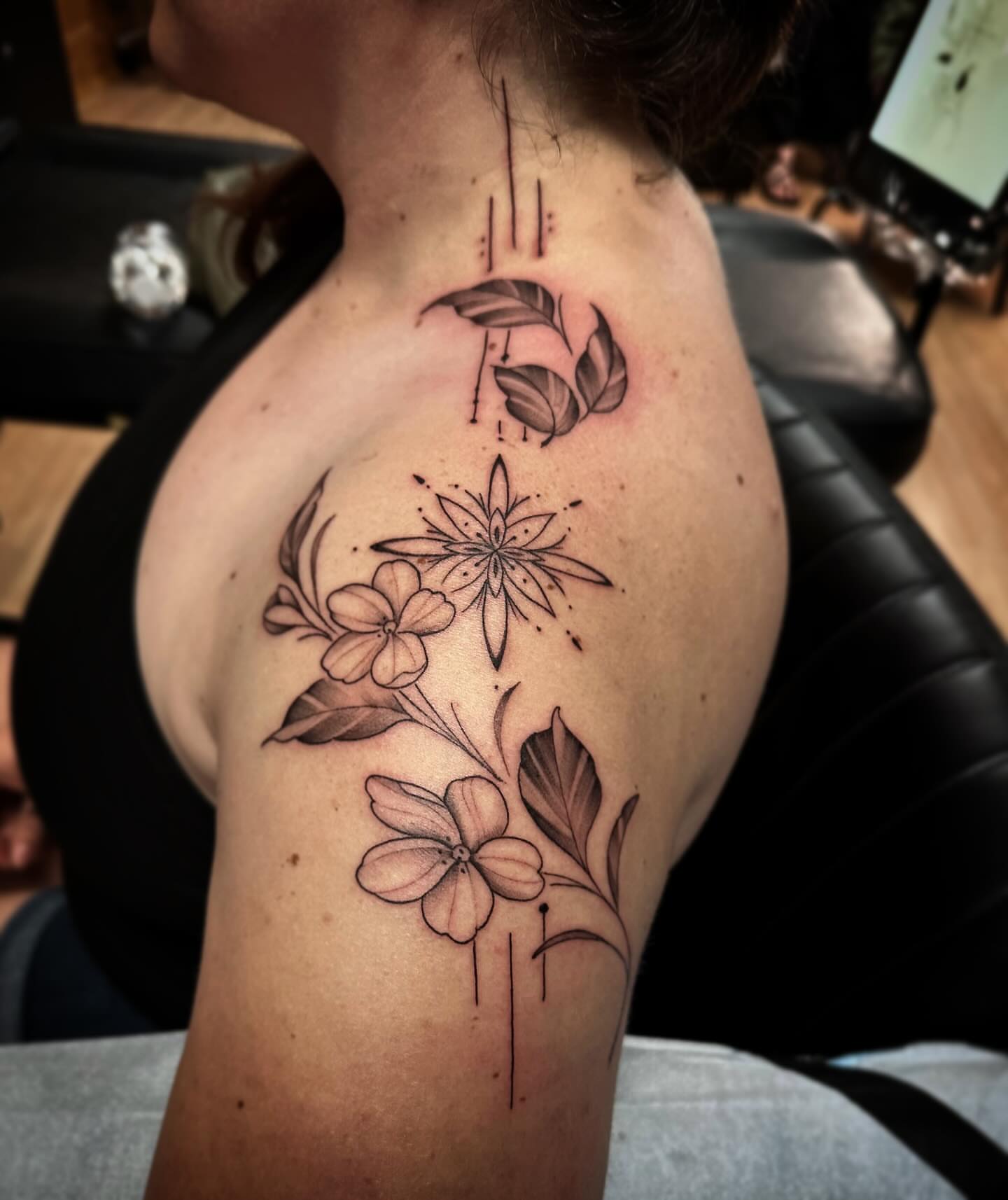 Floral arrangement black and grey tattoo on the shoulder by Sebastian Livingston