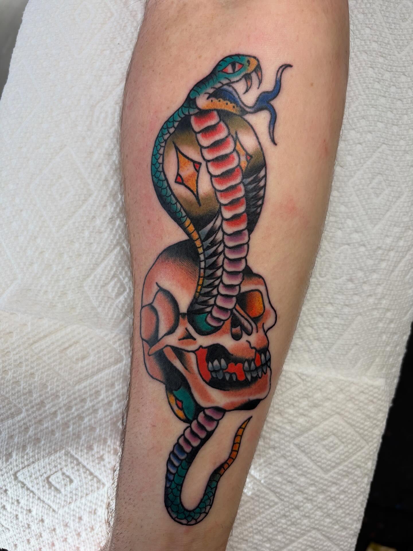 Snake and skull American traditional tattoo on the forearm by Ben Whyte