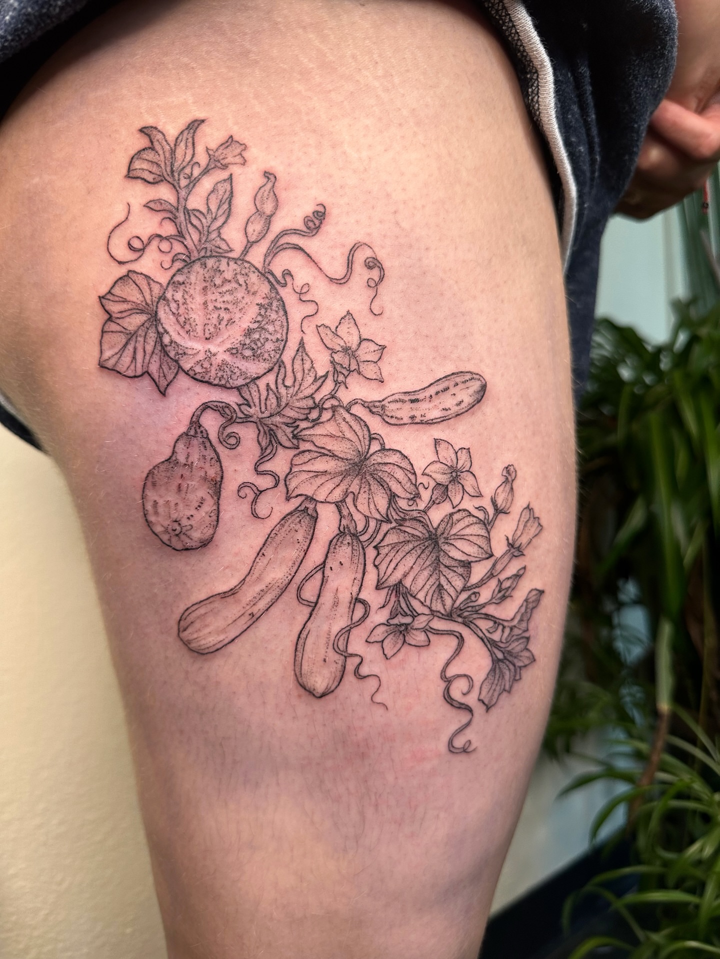 Vegetables and flowers black and grey tattoo on the thigh by kenzie hunter