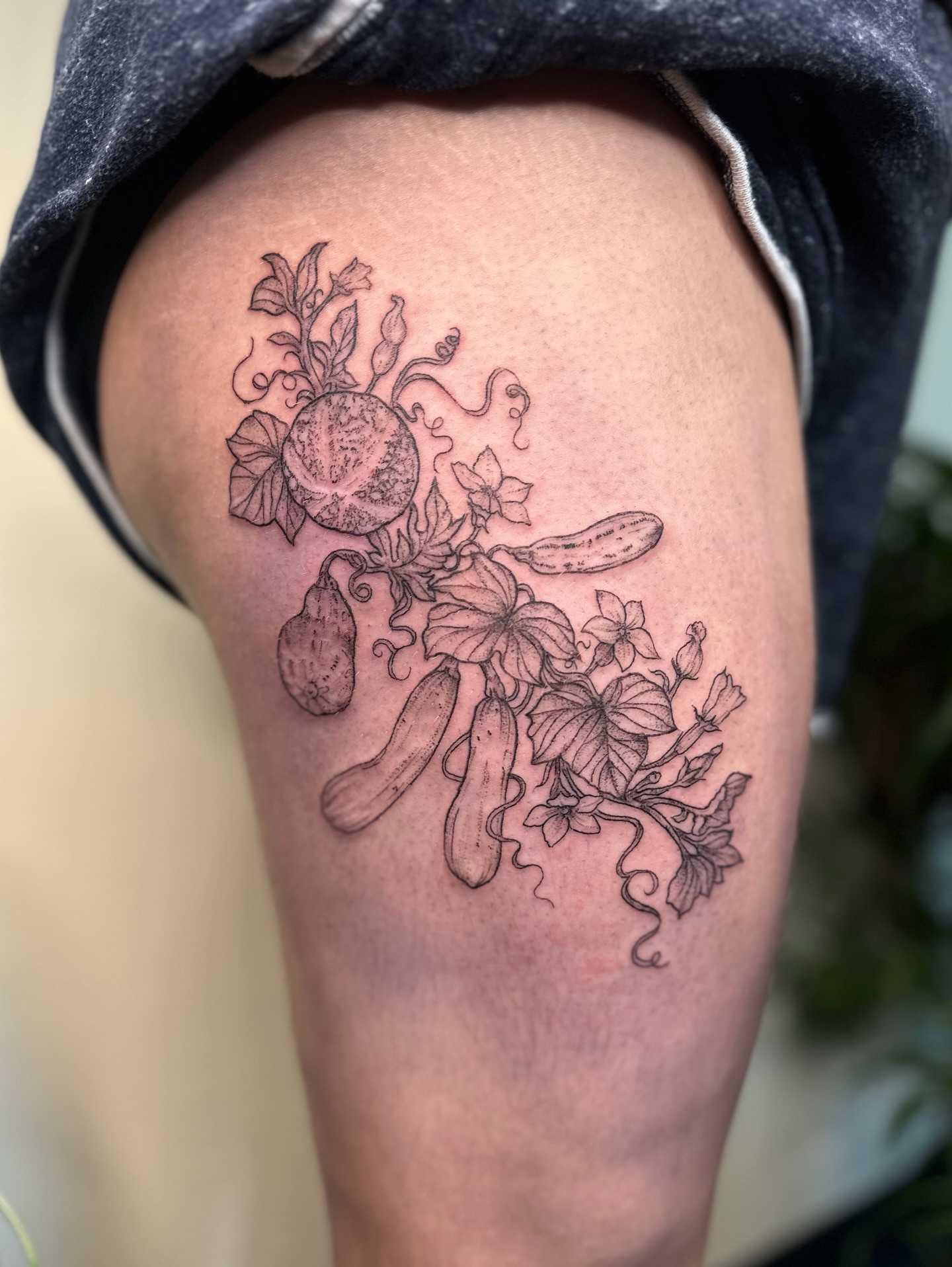 Vegetables and flowers black and grey tattoo on the thigh by kenzie hunter