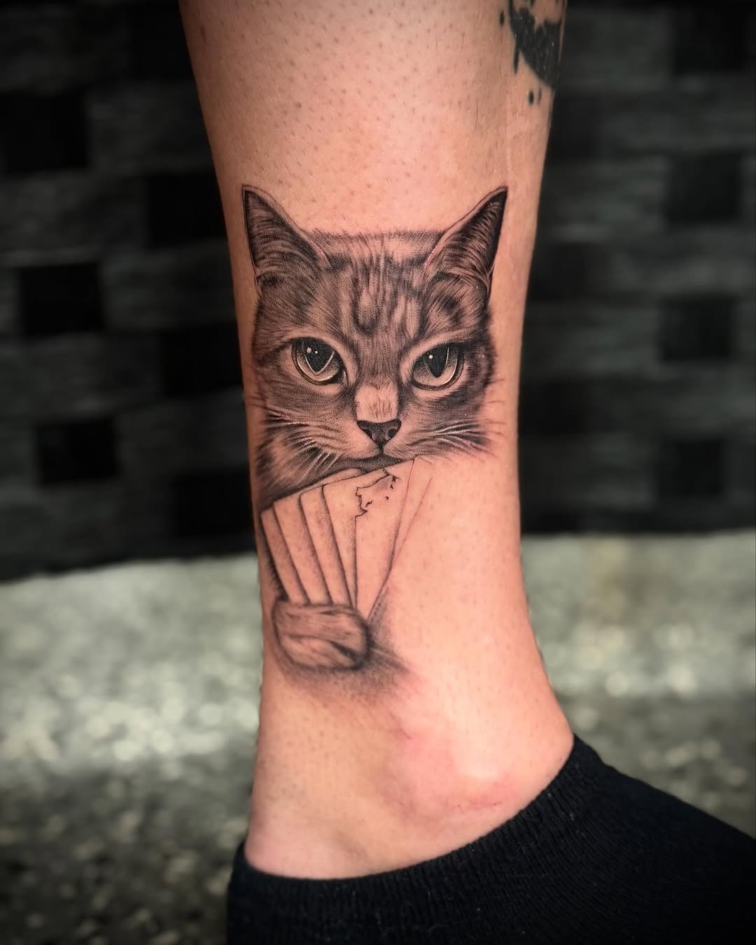 Cat holding playing cards realism tattoo on the forearm by oh hey, robin.