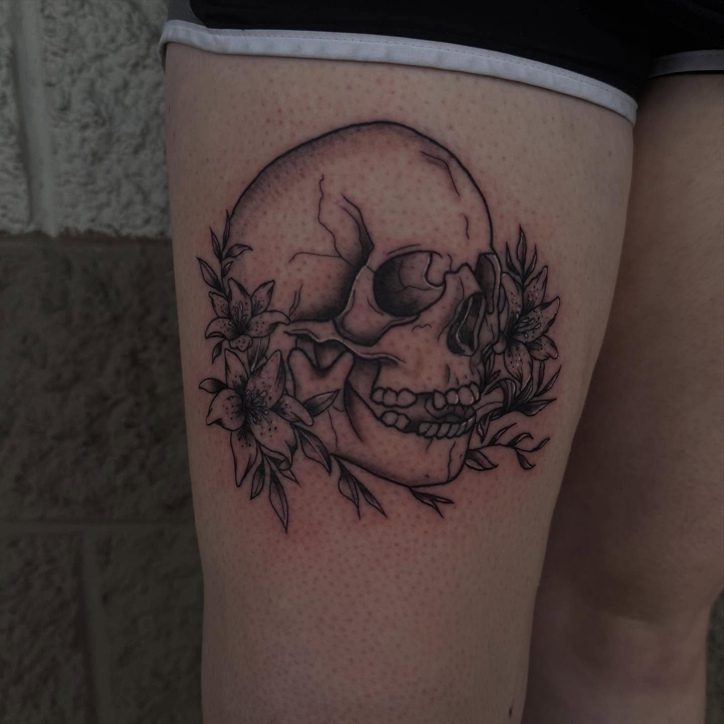 Skull and flowers realism tattoo on the thigh by Kylee langford 🧿