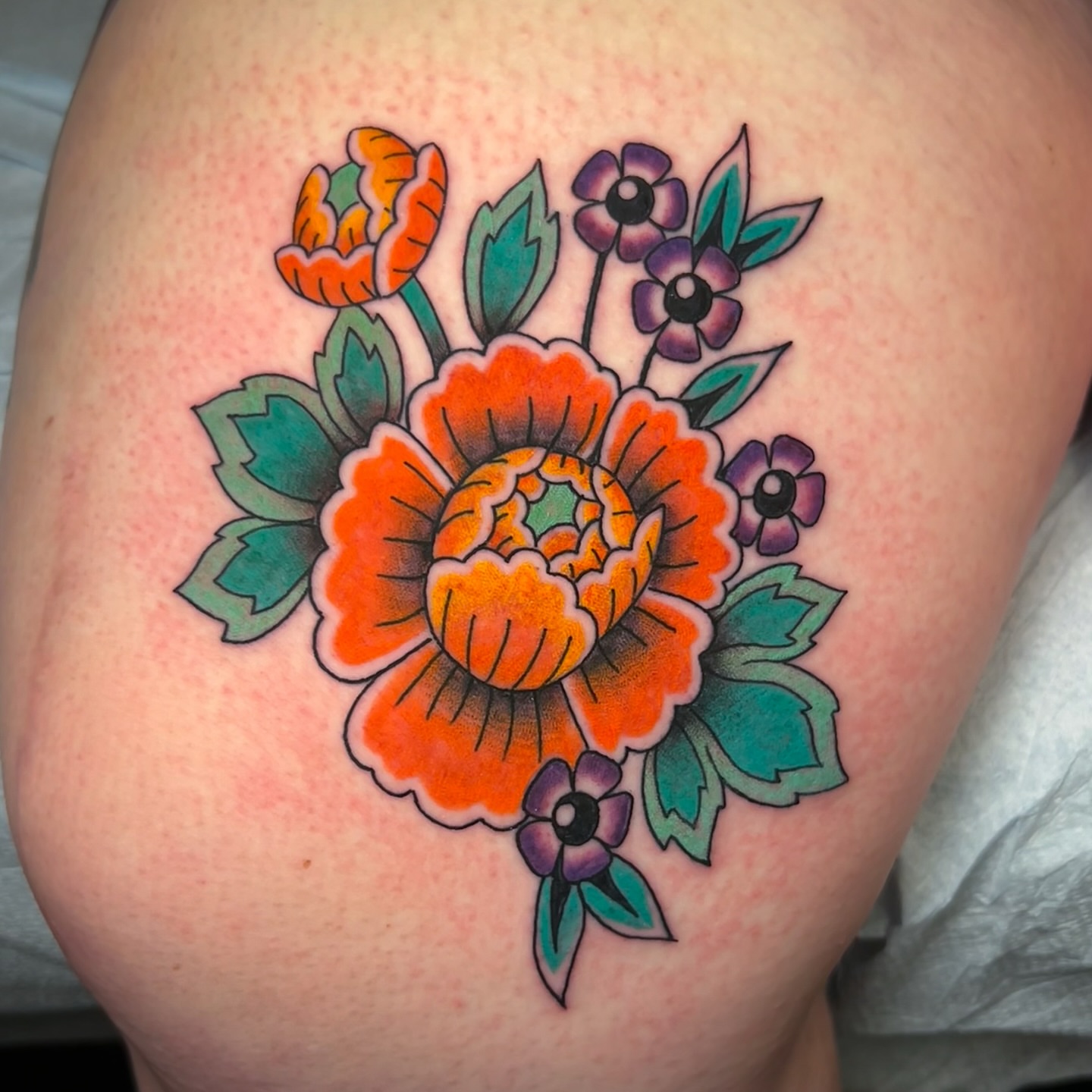 Floral bouquet American traditional tattoo on the thigh by Jessica Oram Brockman, Dayton, Ohio