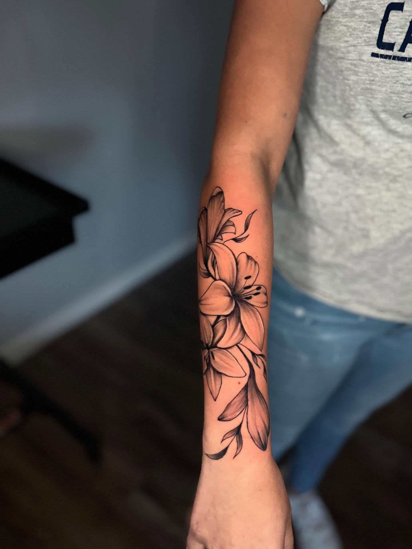 Lilies black and grey tattoo on the forearm by AJ