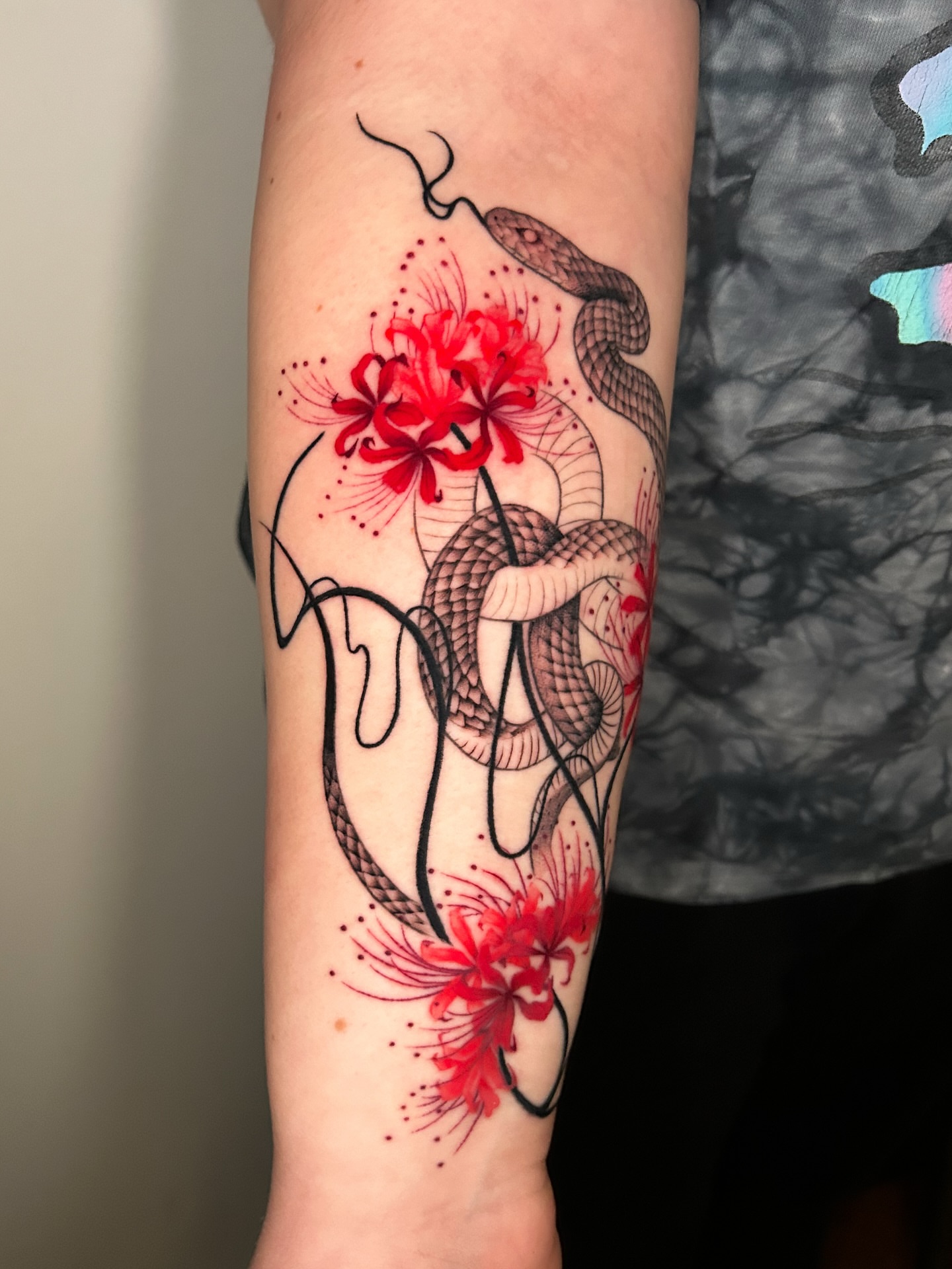 Snake and flowers dotwork tattoo on the forearm by Crystal Thorns