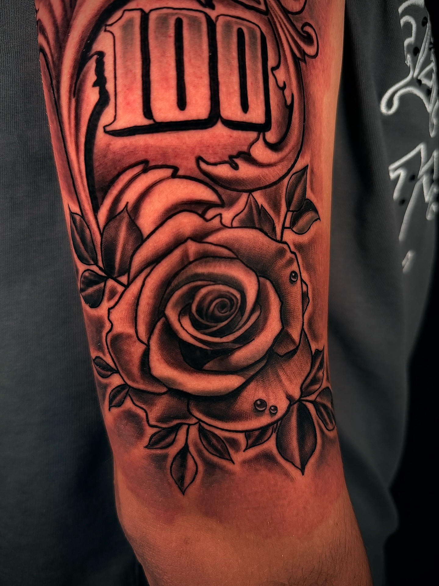 Rose and '100' black and grey tattoo on the forearm by Alex macoco, Houston, Texas