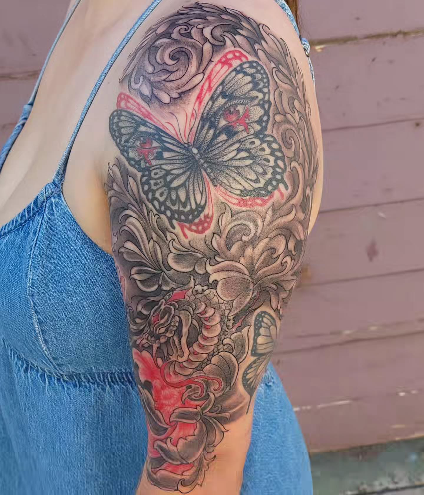 Butterfly and floral American traditional tattoo on the upper arm by Austin Berry