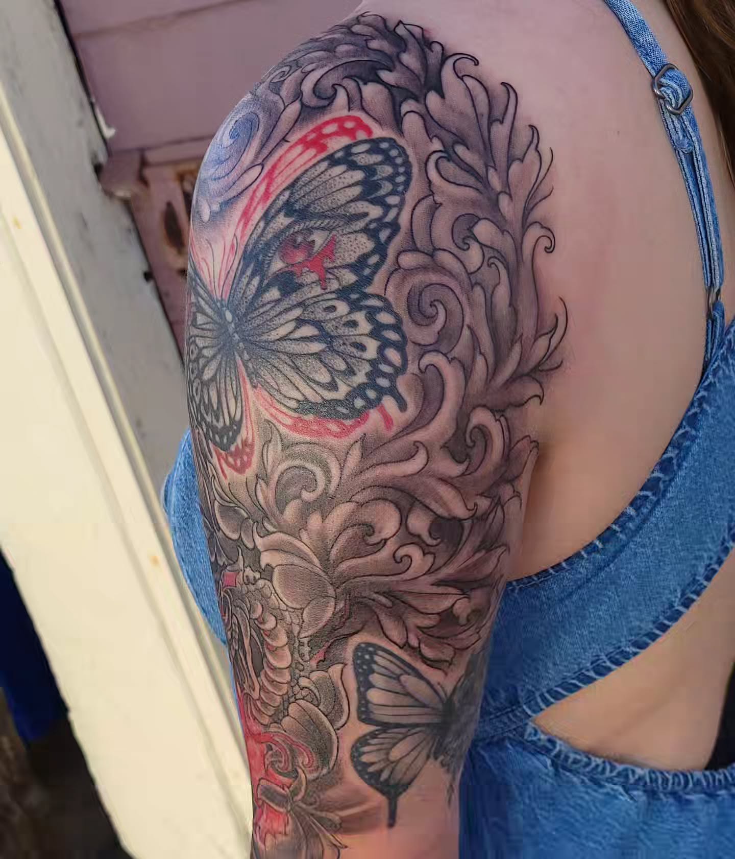 Butterfly and floral realism tattoo on the upper arm by Austin Berry