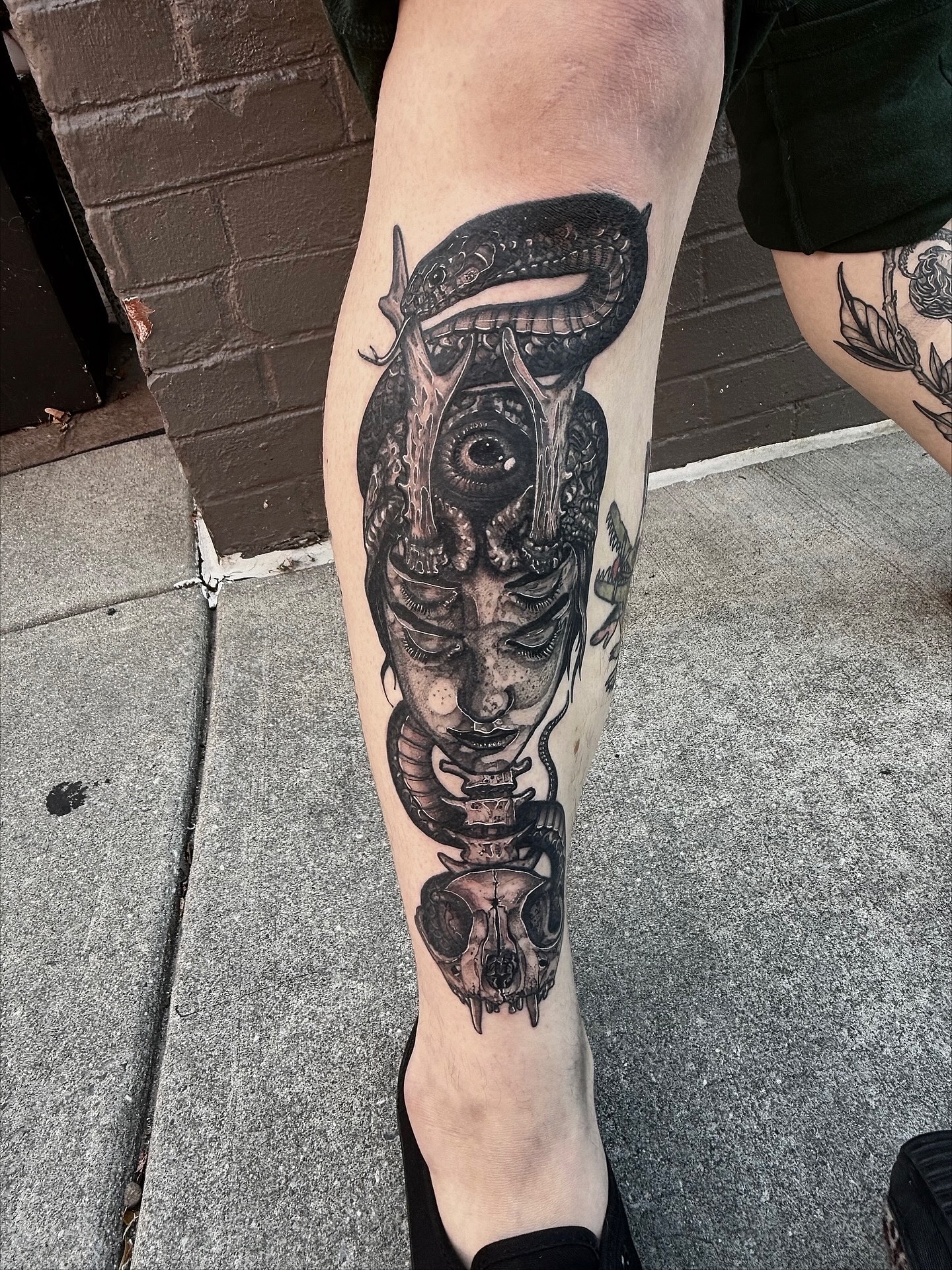 Skull and snake dark realism tattoo on the calf by Danielle