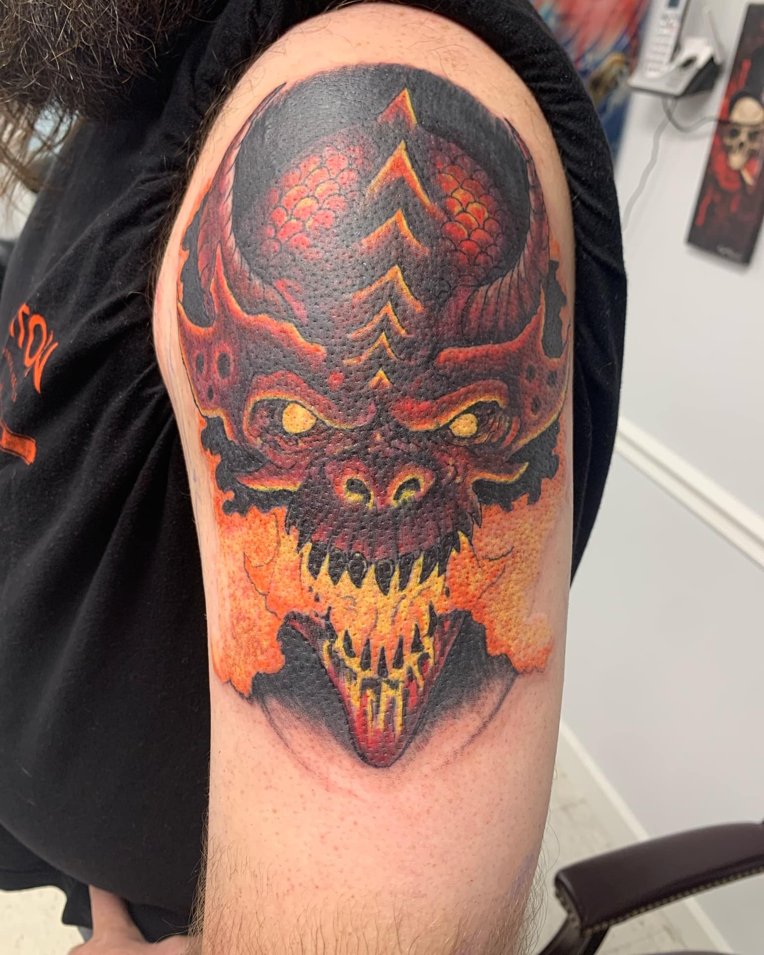 Demon face tattoo on the shoulder by Russell Lucas