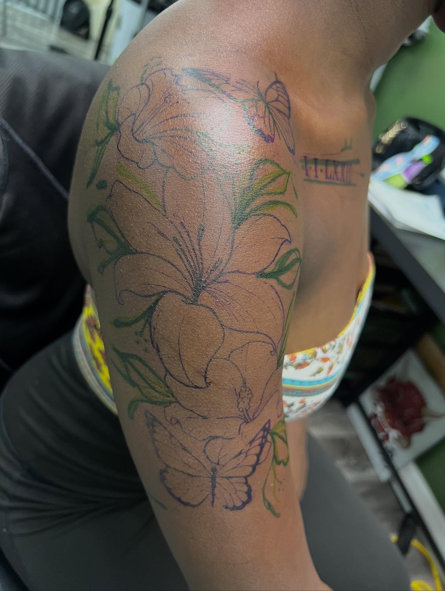 Flowers and butterflies new school tattoo on the upper arm by Monii Arreola