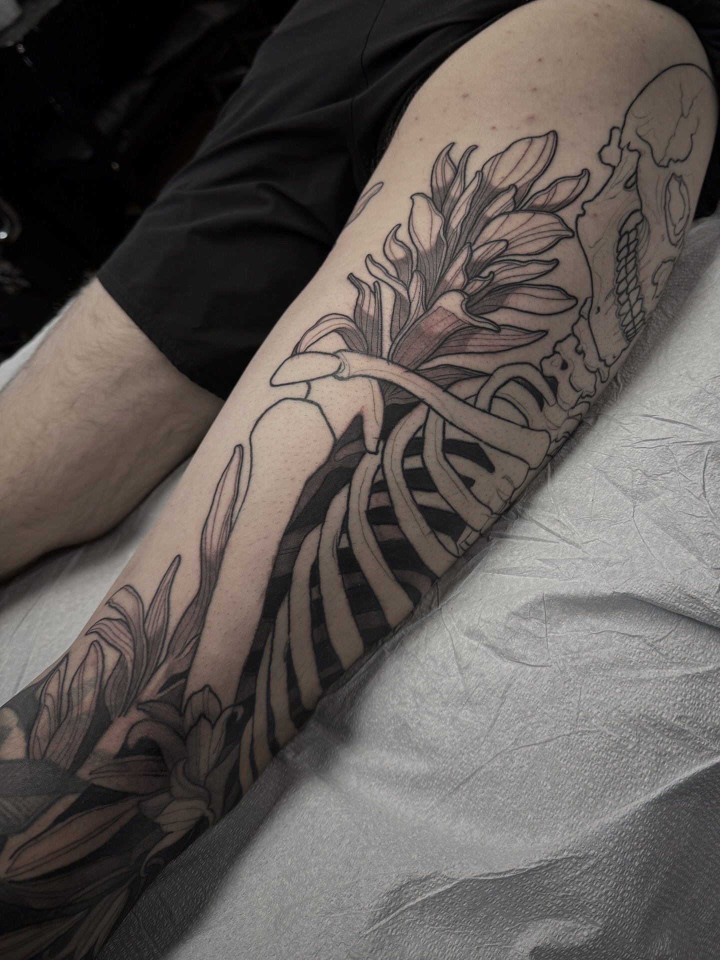 Floral skeleton realism tattoo on the forearm by gina